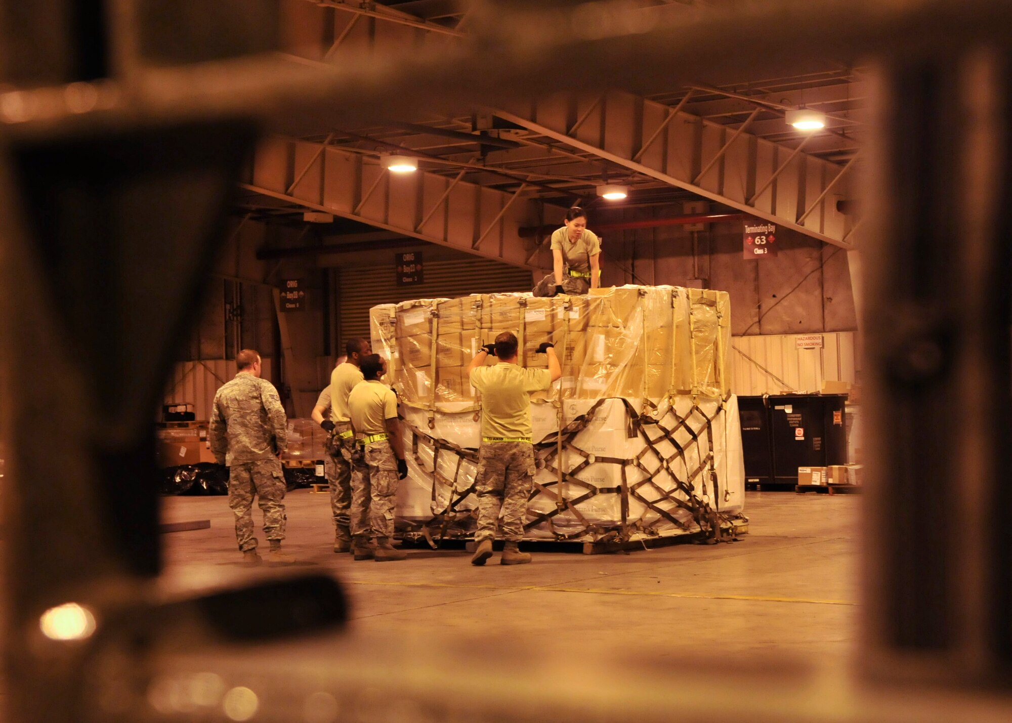 YOKOTA AIR BASE, Japan -- Airmen from the 374th Logistics Readiness Squadron and 730th Air Mobility Squadron pack and secure a pallet of relief supplies inside a cargo warehouse here March 20. The supplies will be delivered to Northern Japan to support Operation Tomodachi. (U.S. Air Force photo/Airman 1st Class Andrea Salazar)(Released)