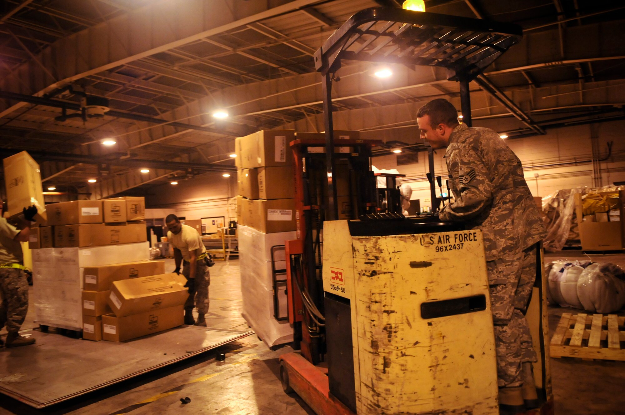 YOKOTA AIR BASE, Japan -- Airmen from the 374th Logistics Readiness Squadron and 730th Air Mobility Squadron pack and secure a pallet of relief supplies inside a cargo warehouse here March 20. The supplies will be delivered to Northern Japan to support Operation Tomodachi. (U.S. Air Force photo/Airman 1st Class Andrea Salazar)(Released)