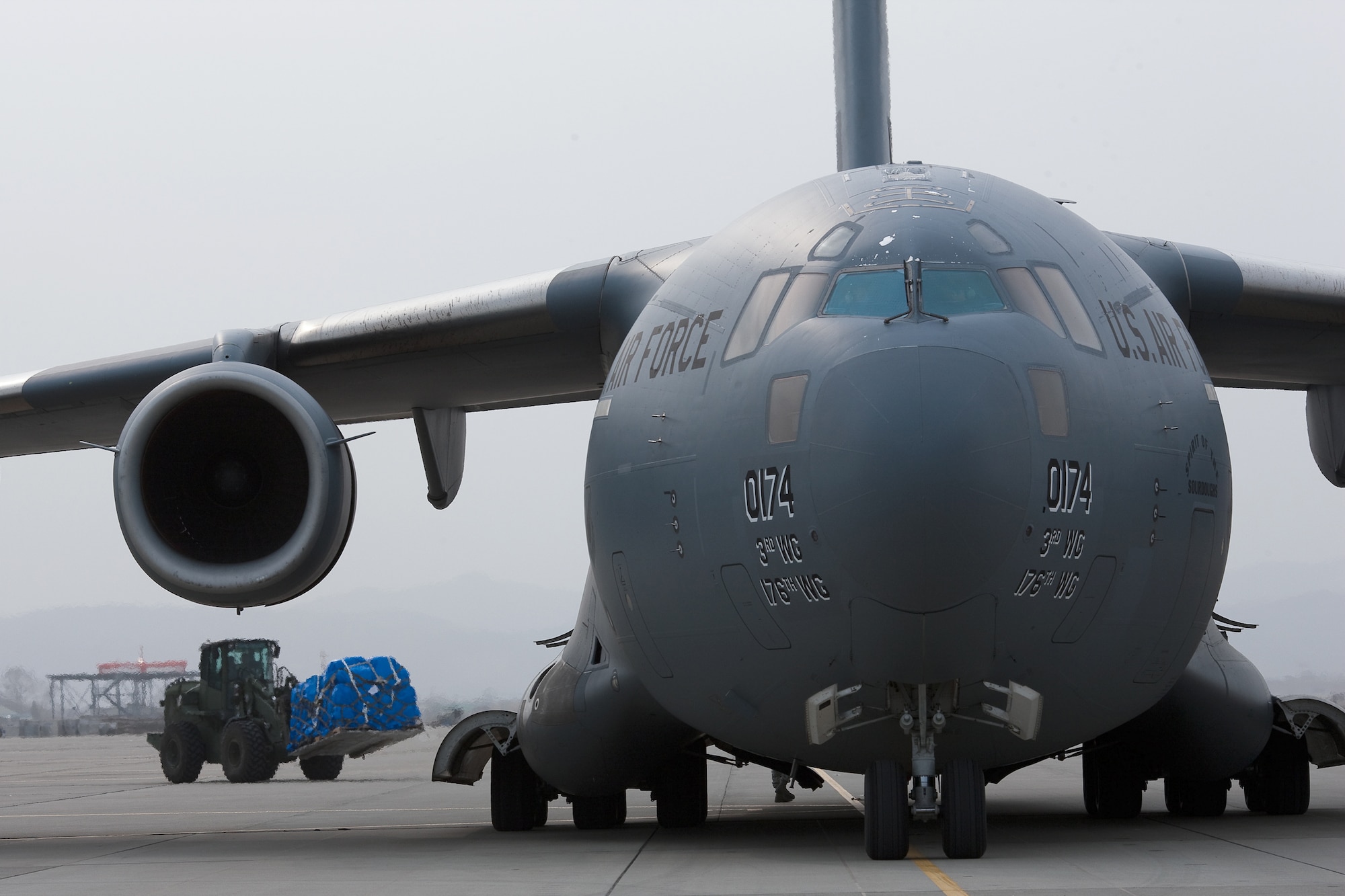 SENDAI AIRPORT, Japan -- Members of the 320th Special Tactics Squadron unload ten pallets of humanitarian relief supplies here March 20. The supplies were delivered by the first C-17 Globemaster III aircraft to land at the airport. (U.S. Air Force photo/Osakabe Yasuo) 
