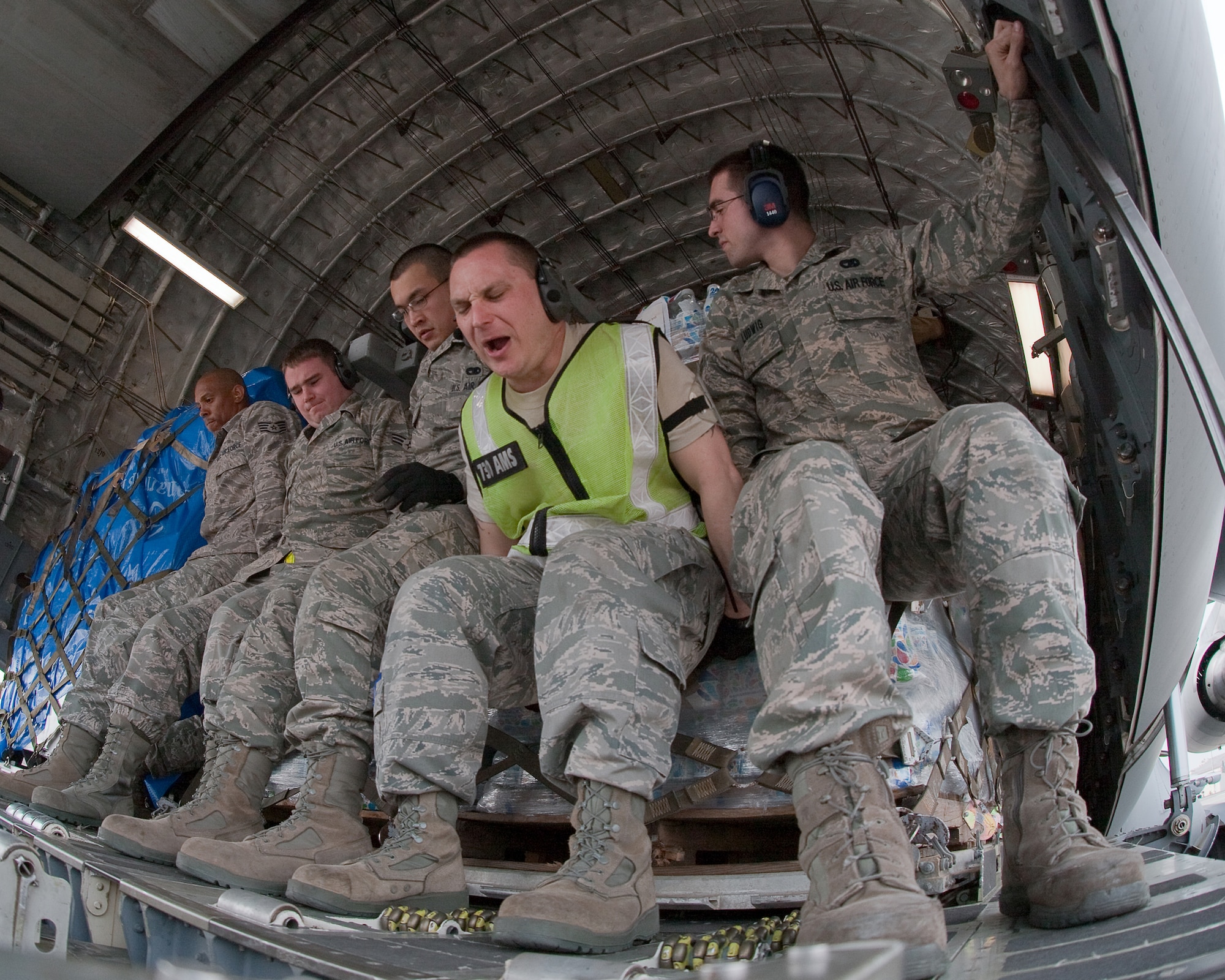 YOKOTA AIR BASE, Japan -- 730th Air Mobility Squadron members load ten pallets of food, water and blankets onto a C-17 Globalmaster III here March 20. This was the first C-17 carrying humanitarian relief supplies to land at Sendai Airport. (U.S. Air Force photo/Osakabe Yasuo)