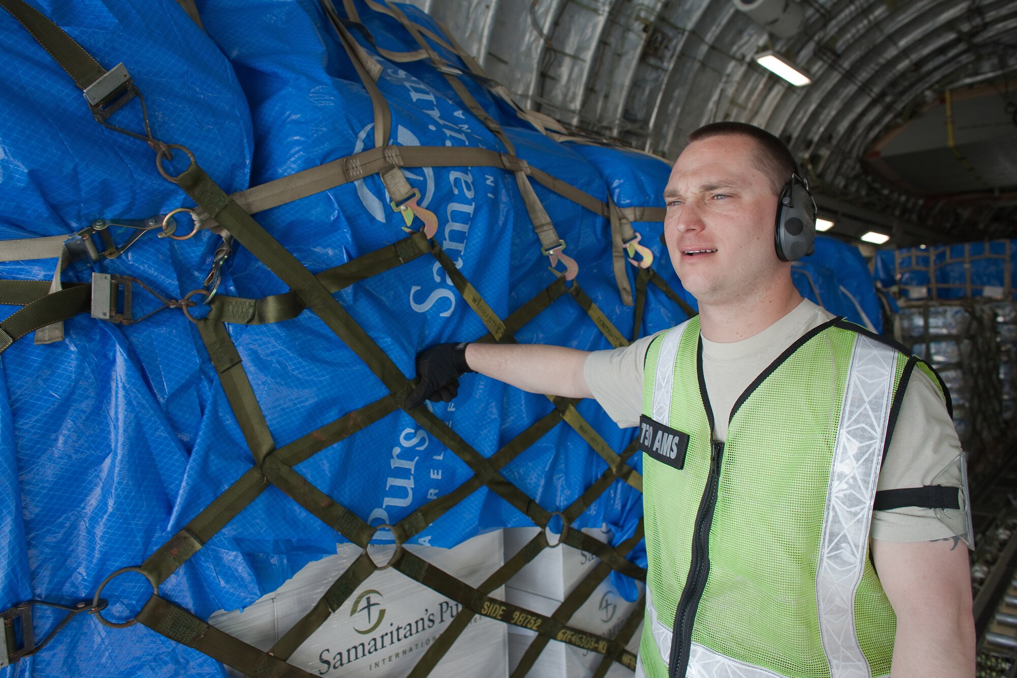 YOKOTA AIR BASE, Japan -- Staff Sgt. Jason Doyle, 730th Air Mobility Squadron, finishes loading ten pallets of humanitarian relief supplies onto a C-17 Globemaster III here March 20. This was the first C-17 carrying humanitarian relief supplies to land at Sendai Airport. (U.S. Air Force photo/Osakabe Yasuo)(Released)