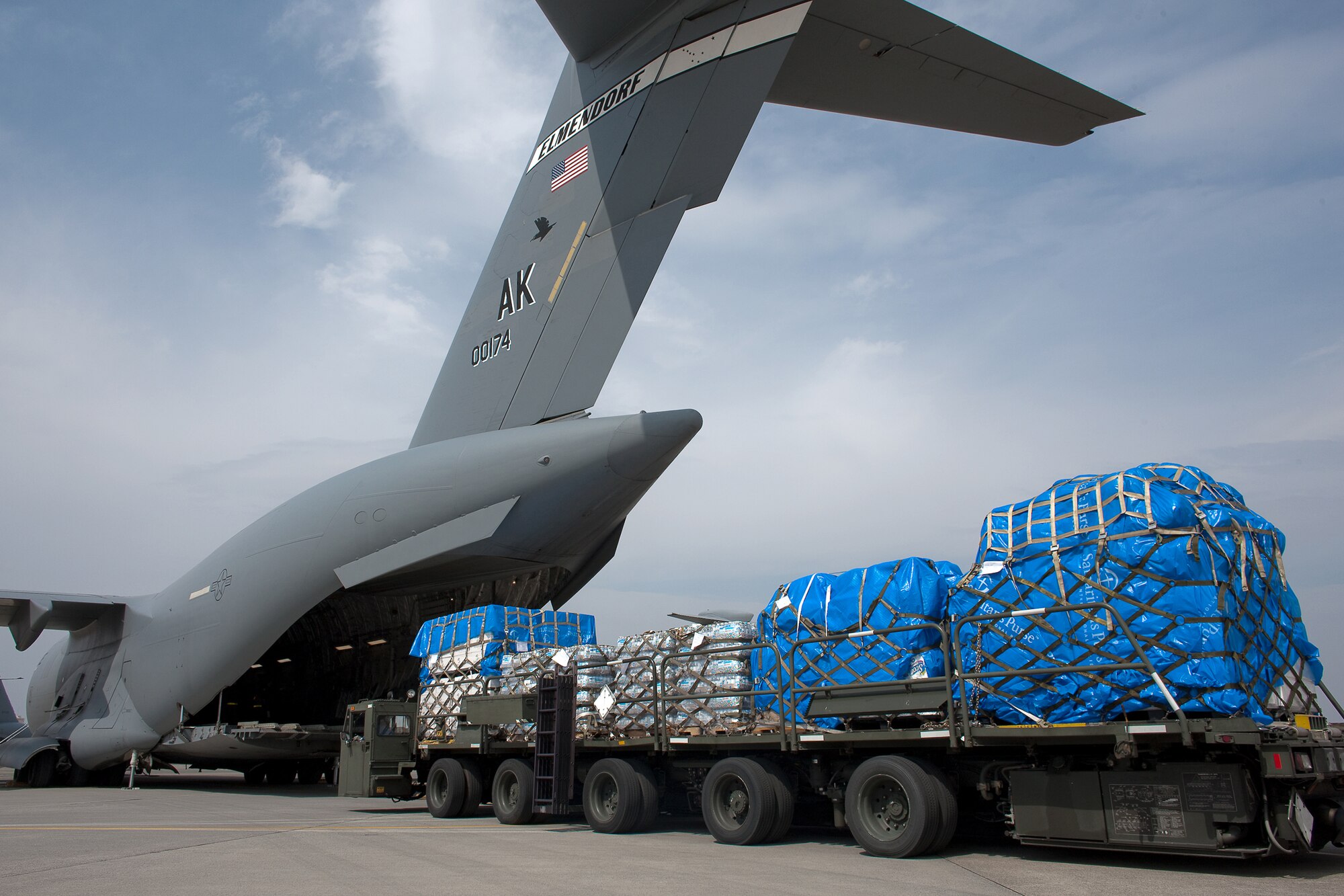 YOKOTA AIR BASE, Japan -- Members of the 730th Air Mobility Squadron load ten pallets of water, food and blankets onto a C-17 Globalmaster III aircraft here March 20. These were the first humanitarian relief supplies to be delivered to Sendai. (U.S. Air Force photo/Osakabe Yasuo)