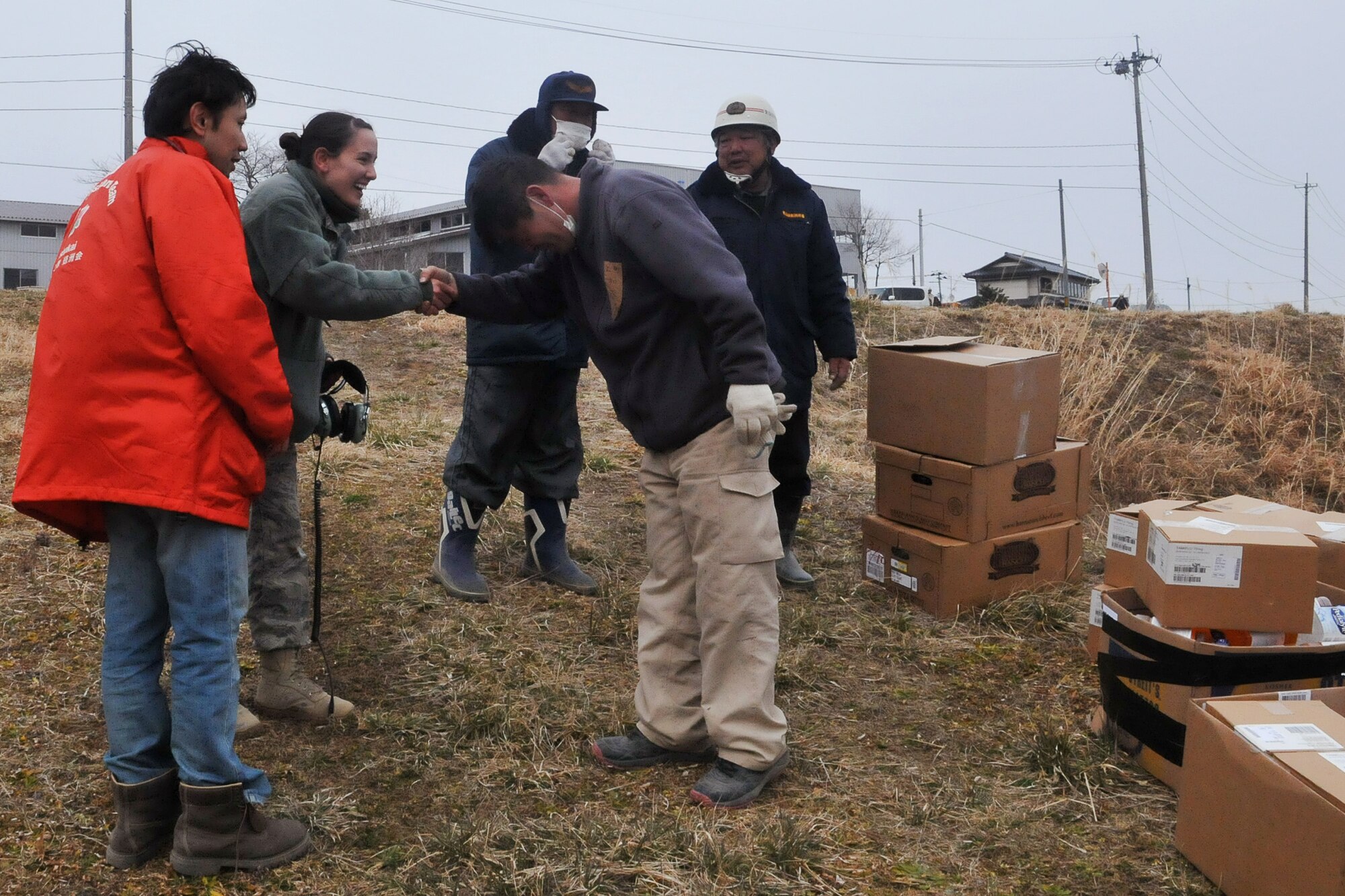 KESSENUMA CITY, Japan -- A Japanese relief worker shows his appreciation to Airman 1st Class Veronica Cox, after a pair of HH-60s deliver food, water and medical supplies here March 20. The 33rd Rescue Squadron successfully transported supplies to displaced peoples in Kessenuma City, in support of Operation Tomodachi. Kessenuma experienced massive destruction from the earthquake and tsunami in northeastern Japan, March 11. (U.S. Air Force photo/2nd Lt. Christopher Love) 