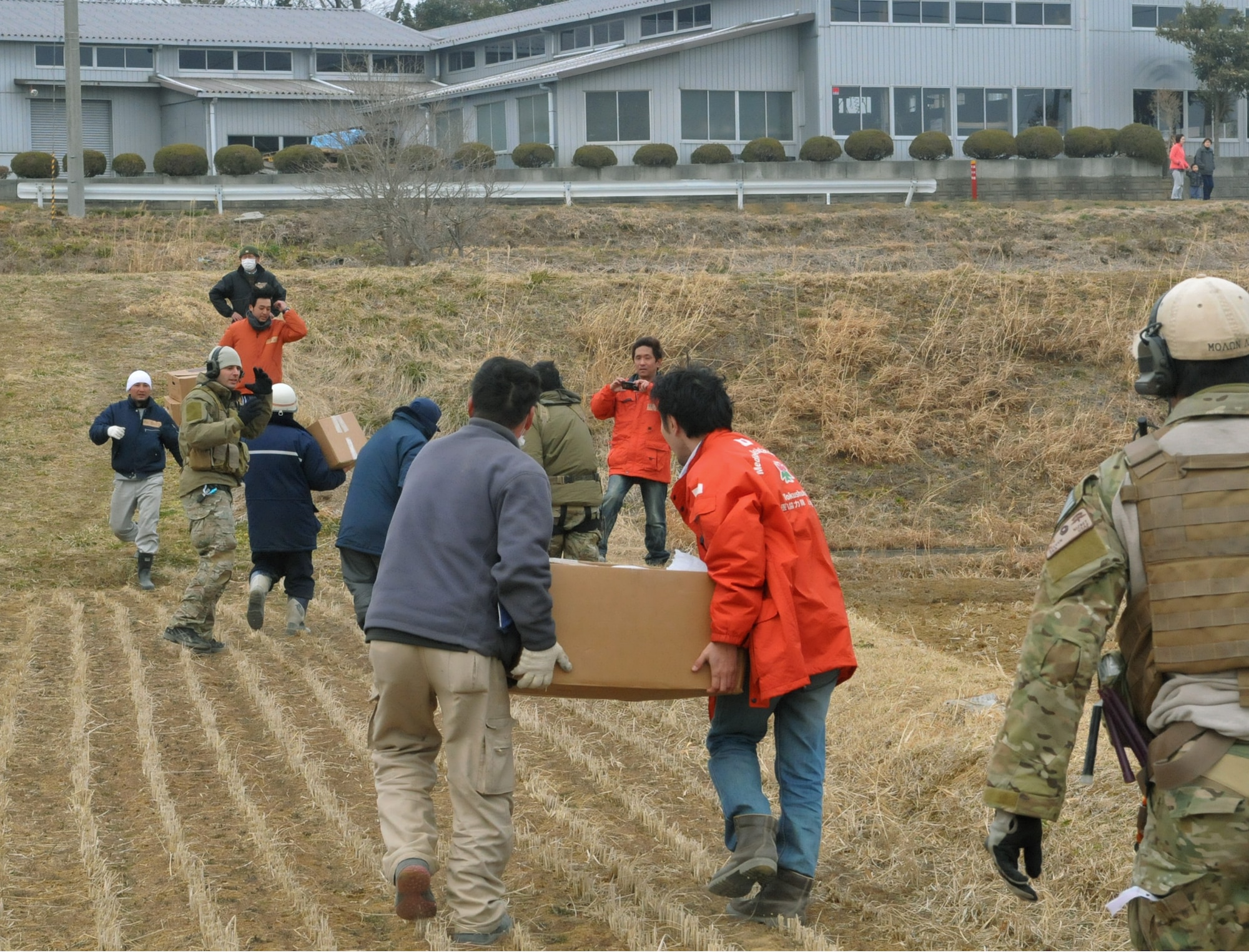 YOKOTA AIR BASE, Japan -- Airmen work alongside a team of Japanese medical workers to unload food, water and medical supplies here  March 20 from a pair of HH-60s,. The 33rd Rescue Squadron successfully transported supplies to displaced people in Kessenuma City, in support of Operation Tomodachi. Kessenuma experienced massive destruction from the earthquake and tsunami in northeastern Japan, March 11. (U.S. Air Force photo/2nd Lt. Christopher Love) 