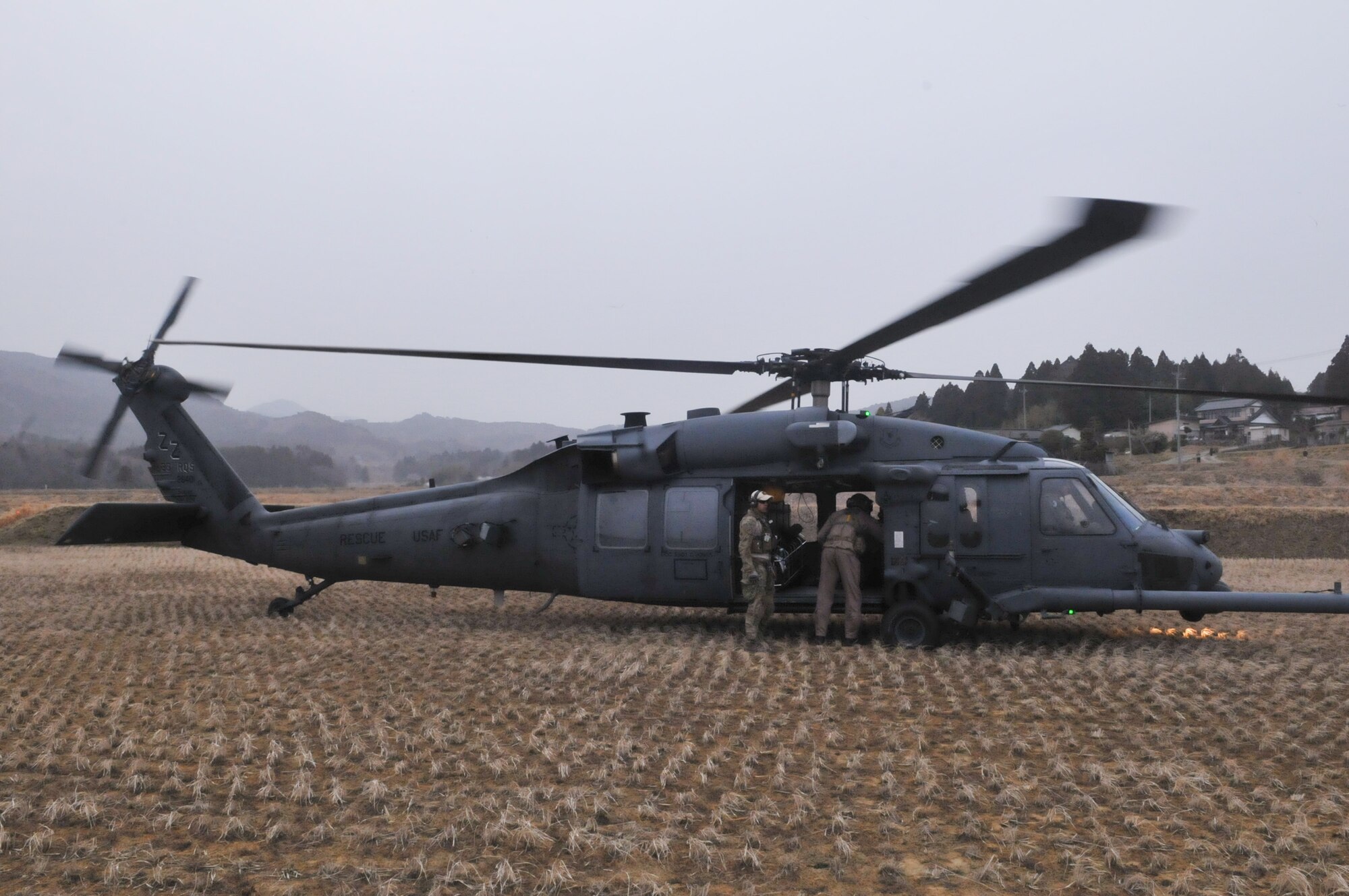 KESSENUMA CITY, Japan -- Two airmen carry medical supplies to an HH-60 prior to take off here, March 20. The 33rd Rescue Squadron successfully transported supplies to displaced peopls in Kessenuma City, in support of Operation Tomodachi. Kessenuma experienced massive destruction from the earthquake and tsunami in northeastern Japan, March 11. (U.S. Air Force photo/2nd Lt. Christopher Love) 