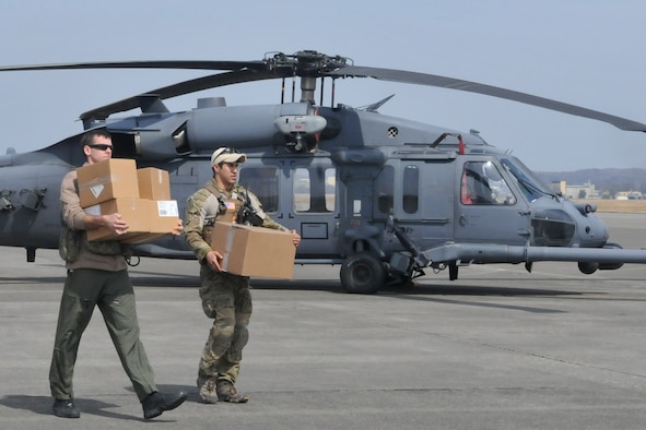 YOKOTA AIR BASE, Japan -- Two airmen carry medical supplies to an HH-60 prior to take off here, March 20. The 33rd Rescue Squadron successfully transported supplies to displaced peoples in Kessenuma City, in support of Operation Tomodachi. Kessenuma experienced massive destruction from the earthquake and tsunami in northeastern Japan, March 11. (U.S. Air Force photo/2nd Lt. Christopher Love) 