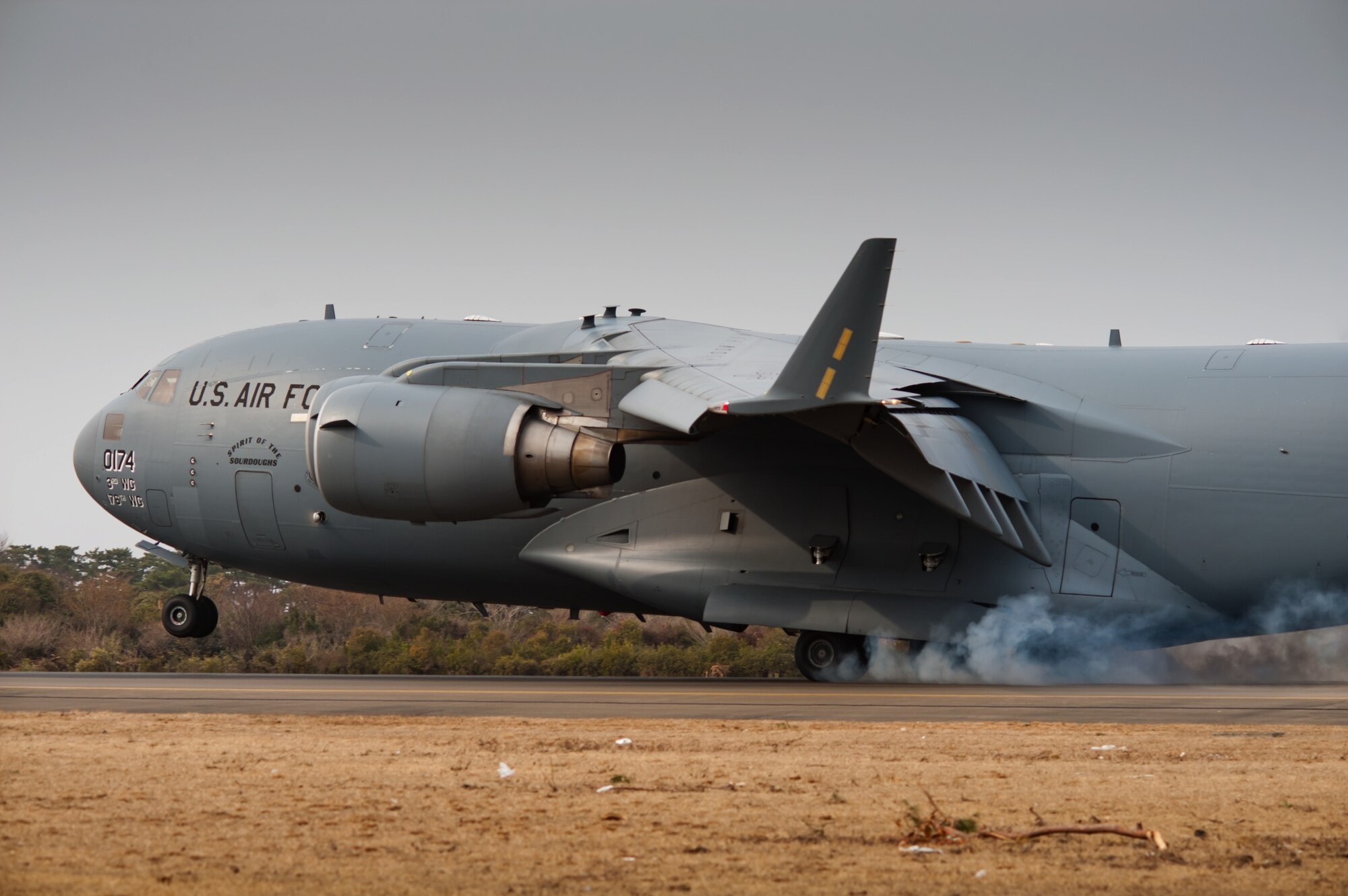 SENDAI AIRPORT, Japan -- A C-17 Globemaster II lands here March 20. Members of the 320th Special Tactics Squadron from Kadena Air Base, Japan, reopened the runway to fixed-wing aircraft March 16 and cleared the rest of the runway to accommodate larger aircraft such as the C-17, enabling larger shipments of humanitarian aid to help those affected by the earthquake and tsunami of March 11. (U.S. Air Force photo/Staff Sgt. Samuel Morse)