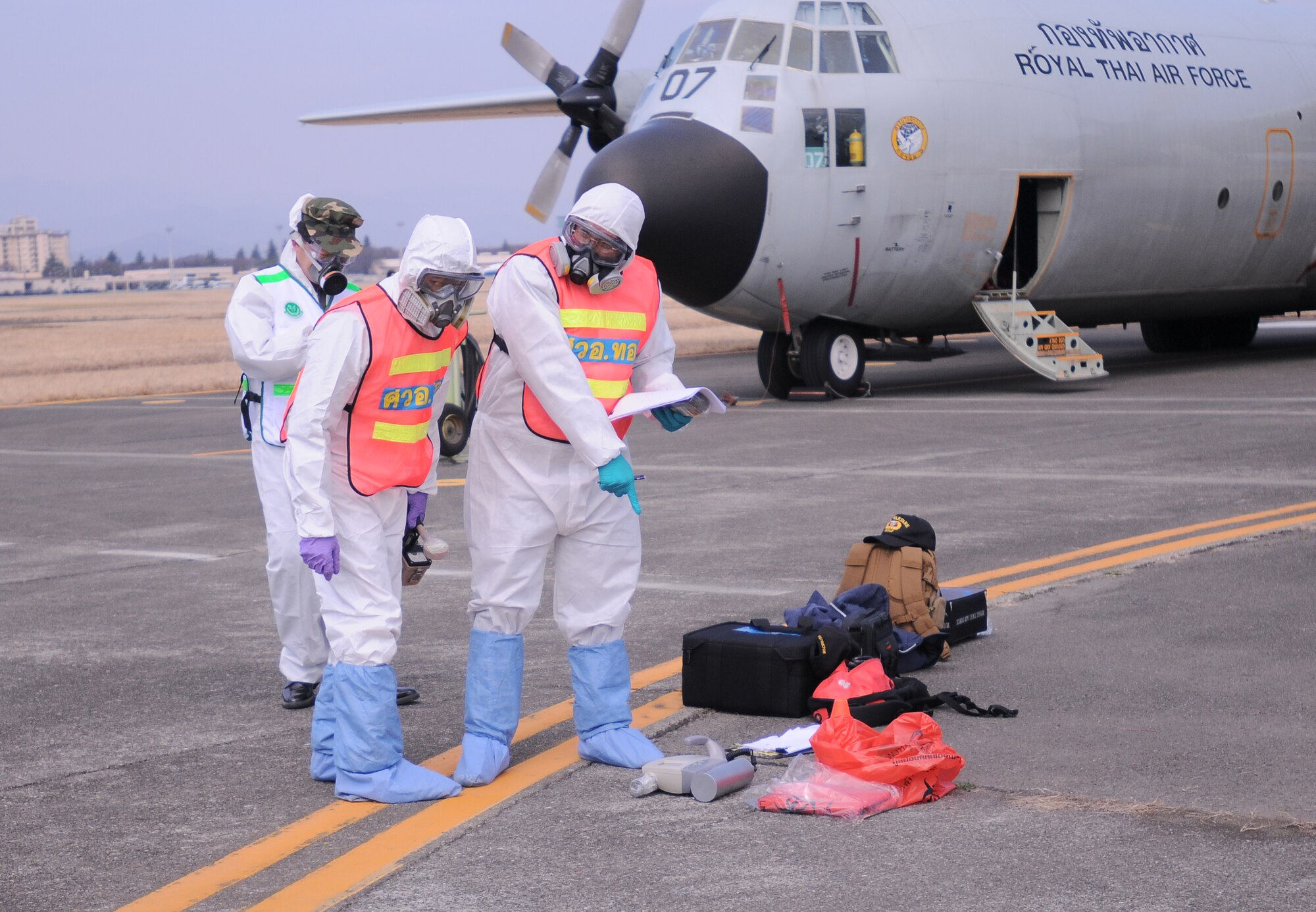 YOKOTA AIR BASE, Japan -- Royal Thai Air Force bio-chemical personnel prepare to check Thailand citizens for contamination here March 20. The citizens were transported from Sendai, Japan, to Yokota before boarding a Royal Thai Air Force C-130 to return to Thailand. (U.S. Air Force photo/Airman 1st Class Krystal M. Garrett) 