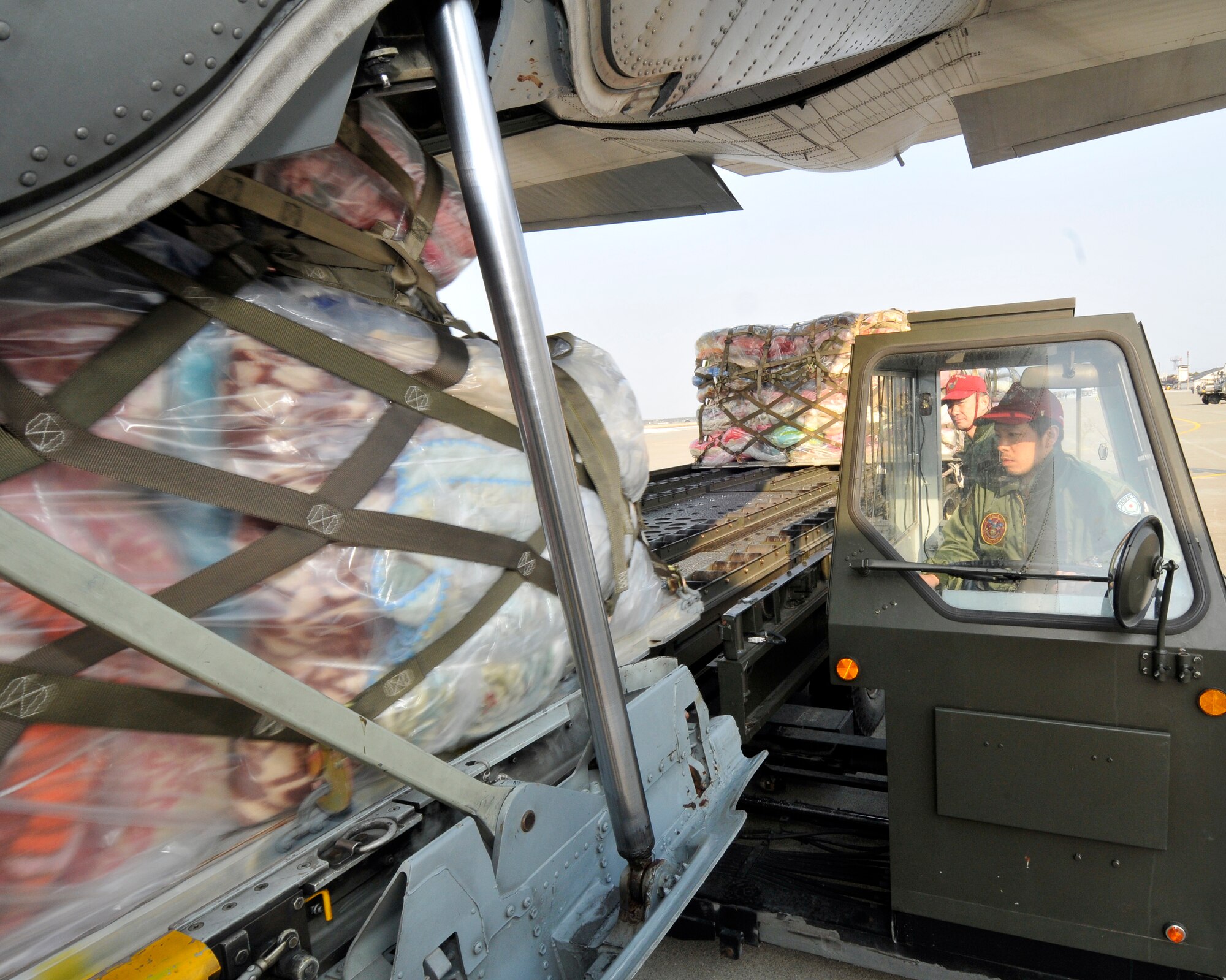 MISAWA AIR BASE, Japan -- A Japan Air Self-Defense Force aircraft load-truck driver, watches as a pallet of blankets and food roles onto his vehicle from a U.S. Navy C-130 Hercules Mar. 19. This C-130 offloaded 3.8 tons of relief supplies destined for earthquake survivors in the Miyagi Prefecture. (U.S. Air Force photo by Tech. Sgt. Phillip Butterfield\Released)  

