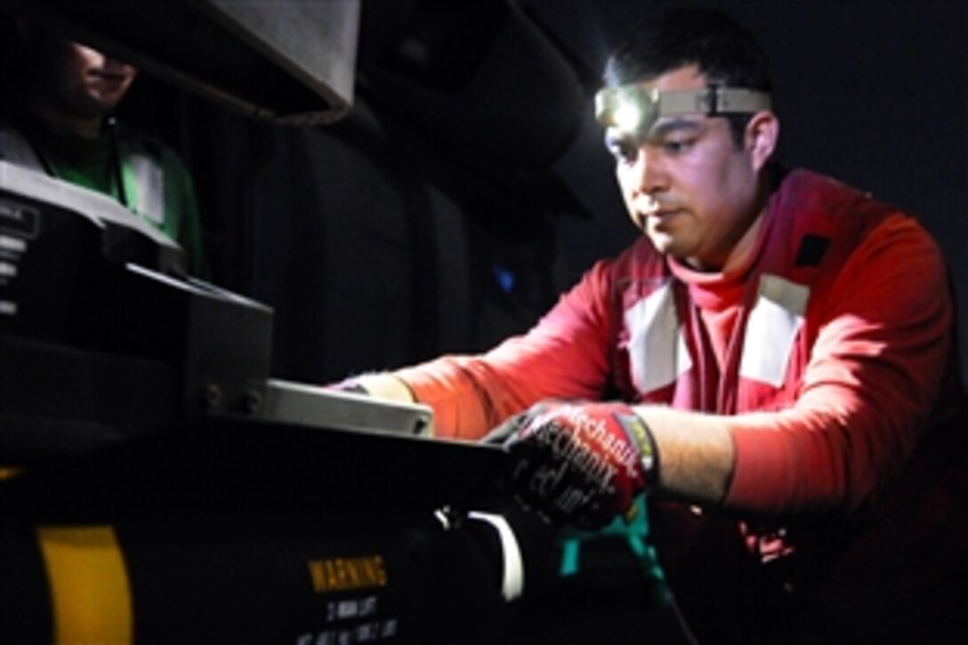 U.S. Navy Petty Officer 1st Class Joseph Federico loads a Hellfire missile on to a MH-60S Knight Hawk helicopter on the flight deck of amphibious assault ship USS Kearsarge  to prepare for Operation Odyssey Dawn missions in the Mediterranean Sea, March 19, 2011.