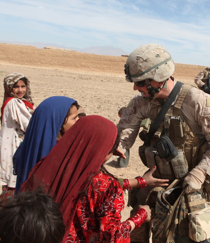 Lance Cpl. Jared Beard, of Hillsboro, N.H., gives candy and toys to children during a patrol through the village March 21.  Beard got the candy and toys from care packages his family sent him.