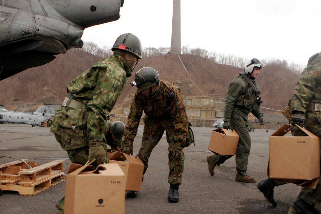 Japanese Self-Defense Force members and a Marine with Marine Medium Helicopter Squadron 262 (Reinforced), 31st Marine Expeditionary Unit, unload water delivered as part of a humanitarian aid and disaster relief operation, March 21. Navy and Marine Corps involvement in the relief mission is part of a larger U.S. government response, coordinated through the U.S. Department of State, aiding the government of Japan in their ongoing relief efforts. As part of Operation Tomodachi, the 31st MEU is ready to support our long-time Japanese partners and to provide assistance when called upon.
