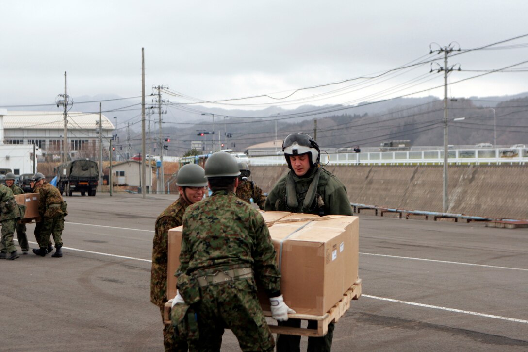 Japanese Self-Defense Force members and a Marine with Marine Medium Helicopter Squadron 262 (Reinforced), 31st Marine Expeditionary Unit, carry a pallets of blankets from helicopters to a staging area here, March 21. The 31st MEU delivered 800 gallons of water and 768 blankets as part of a humanitarian aid and disaster relief operation. Navy and Marine Corps involvement is part of a larger U.S. government response, coordinated through the U.S. Department of State, after a 9.0 earthquake and subsequent tsunami struck Japan causing widespread damage. As part of Operation Tomodachi, the 31st MEU is ready to support our Japanese partners and to provide assistance when called upon.
