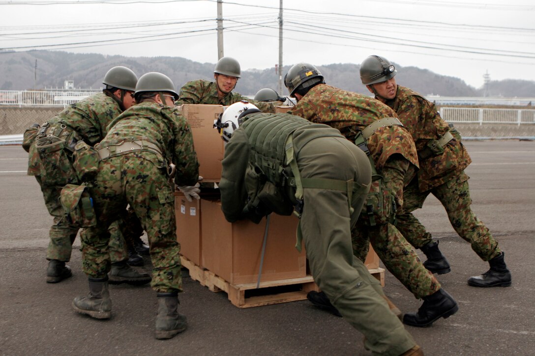 A Marine with Marine Medium Helicopter Squadron 262 (Reinforced), 31st Marine Expeditionary Unit, helps Japanese Self-Defense Forces push a pallet of blankets out of a Marine CH-46E helicopter, March 21. The 31st MEU delivered over 800 gallons of water and 768 blankets to the devastated area. Navy and Marine Corps involvement in the relief mission is part of a larger U.S. government response, coordinated through the U.S. Department of State, aiding the government of Japan in their ongoing relief efforts. As part of Operation Tomodachi, the 31st MEU is ready to support our long-time Japanese partners and to provide assistance when called upon.