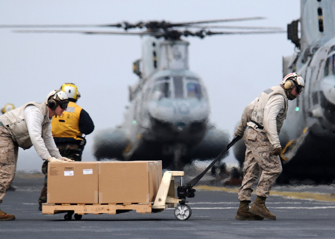 Marines from combat cargo load a CH-46E Sea Knight with humanitarian aid and disaster relief supplies on the flight deck of the forward-deployed amphibious assault ship USS Essex (LHD 2) in support of Operation Tomodachi. Essex, USS Harpers Ferry (LSD 49) and USS Germantown (LSD 42) with the embarked 31st Marine Expeditionary Unit are currently operating off the coast of Hachinohe in northeastern Japan in support of Operation Tomodachi.
