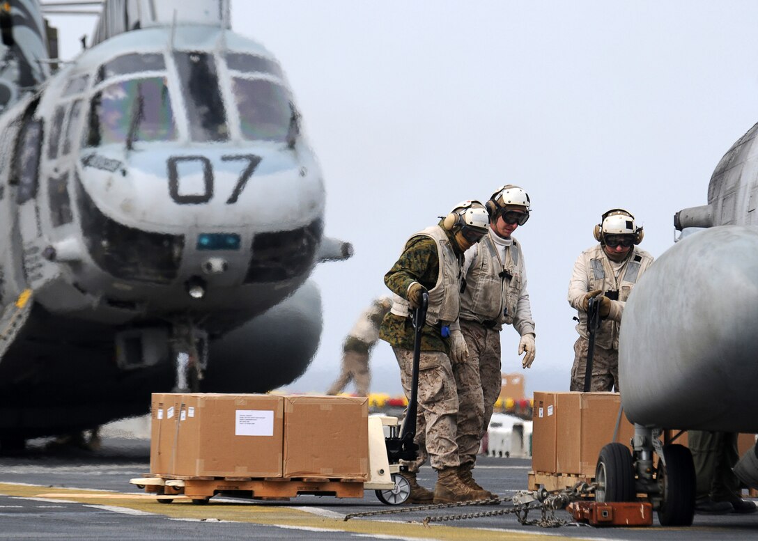 Marines from combat cargo load CH-46E Sea Knight helicopters with Marine Medium Helicopter Squadron 262 (Reinforced), 31st Marine Expeditionary Unit, with humanitarian aid and disaster relief supplies on the flight deck of the forward-deployed amphibious assault ship USS Essex (LHD 2).  The supplies will quickly be delivered to those in need along the coast of Japan. Essex, USS Harpers Ferry (LSD 49) and USS Germantown (LSD 42) with the embarked 31st MEU are currently operating off the coast of Hachinohe in northeastern Japan in support of Operation Tomodachi.