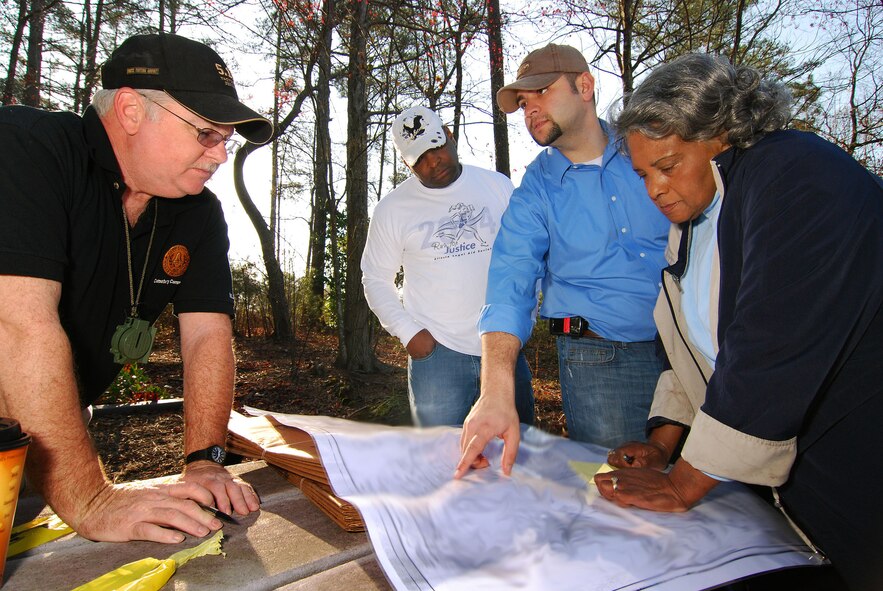 Mr. Mike Jones, Cobb County Cemetery Commissioner, Capt. Darrell Bogan, 94th Airlift Wing Human Resources Development Council, Shaun Shenk, 94th Airlift Wing Public Affairs, and Anette Carter, Mount Sinai Baptist Church Historian, look over a historical map of the local area in the vicinity of the Jonesville cemetery.  The cemetery is located on Dobbins Air Reserve Base but was not part of the government property purchase in the early 1940s and is now the subject of extensive research to determine who owns the property.  (U.S. Air Force photo/ Brad Fallin)