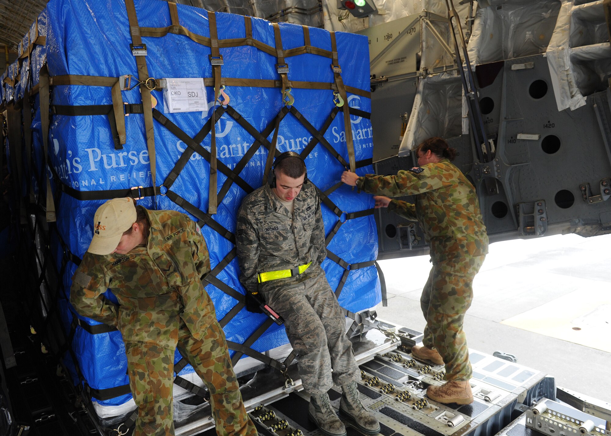YOKOTA AIR BASE, Japan -- Senior Airman Michael Oniones partners with members of the Royal Australian Air Force to load a pallet of humanitarian aid on to a C-17 Globemaster III from RAAF Base Amberley March 21. The humanitarian aid is provided by numerous relief agencies and with assistance from Yokota Airmen, the RAAF delivered 16 pallets of humanitarian aid to Sendai, Japan, in support of Operation Tomodachi. Airman Oniones is assigned to the 730th Air Mobility Squadron. (U.S. Air Force photo/Senior Airman Michael J. Veloz)