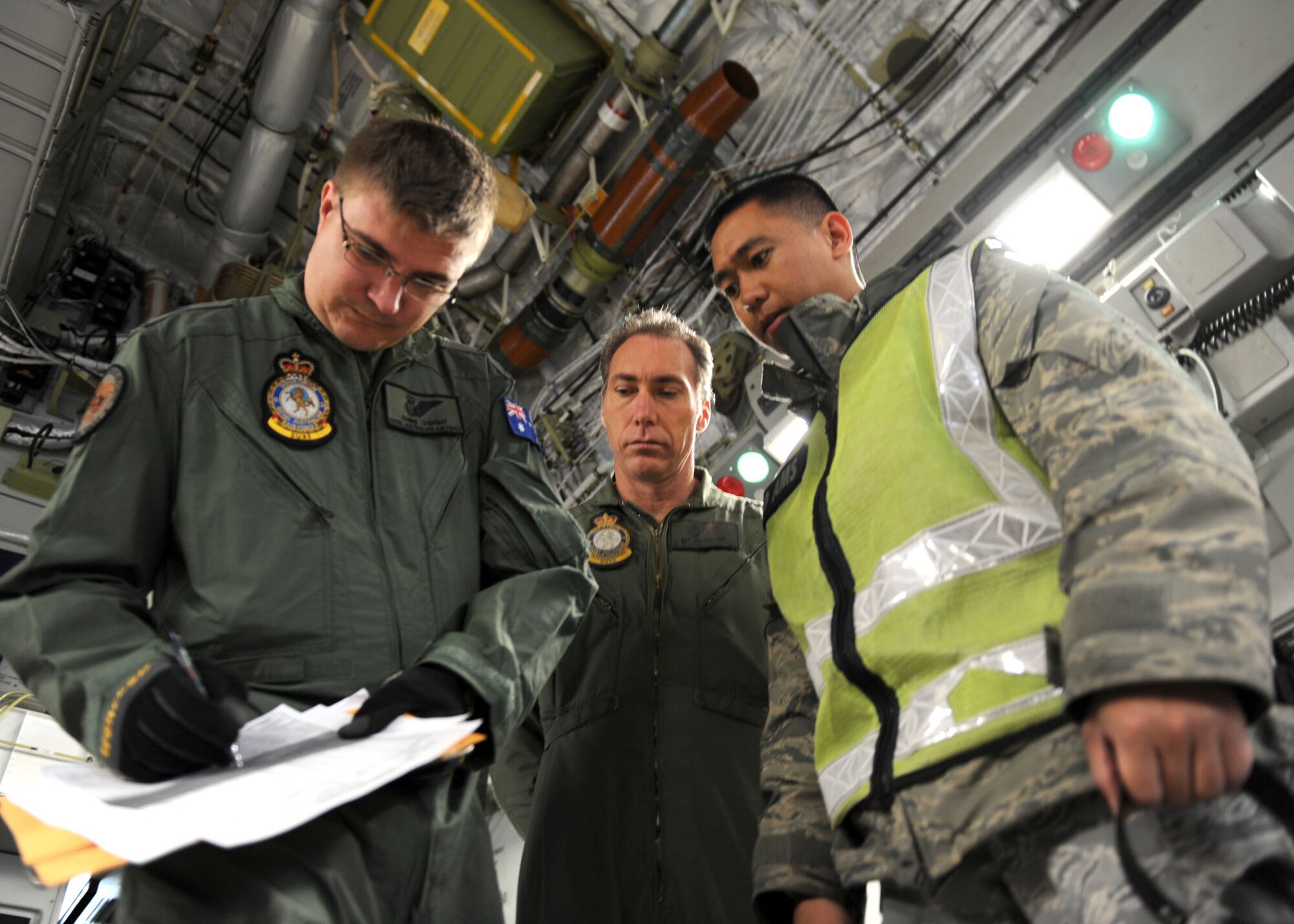 YOKOTA AIR BASE, Japan -- Staff Sgt. Nathaniel Olaguer (right) oversees a cargo manifest for a Royal Australian Air Force C-17 Globemaster III aircrew March 21. With assistance of Yokota Airmen, the RAAF delivered 16 pallets of humanitarian aid to Sendai, Japan, as part of Operation Tomodachi. Operation Tomodachi is a relief support mission aiding those affected by the devastation caused by the recent earthquake and tsunami March 11. Sergeant Olaguer is an air terminal operation controller with the 730th Air Mobility Squadron. (U.S. Air Force photo/Senior Airman Michael J. Veloz)