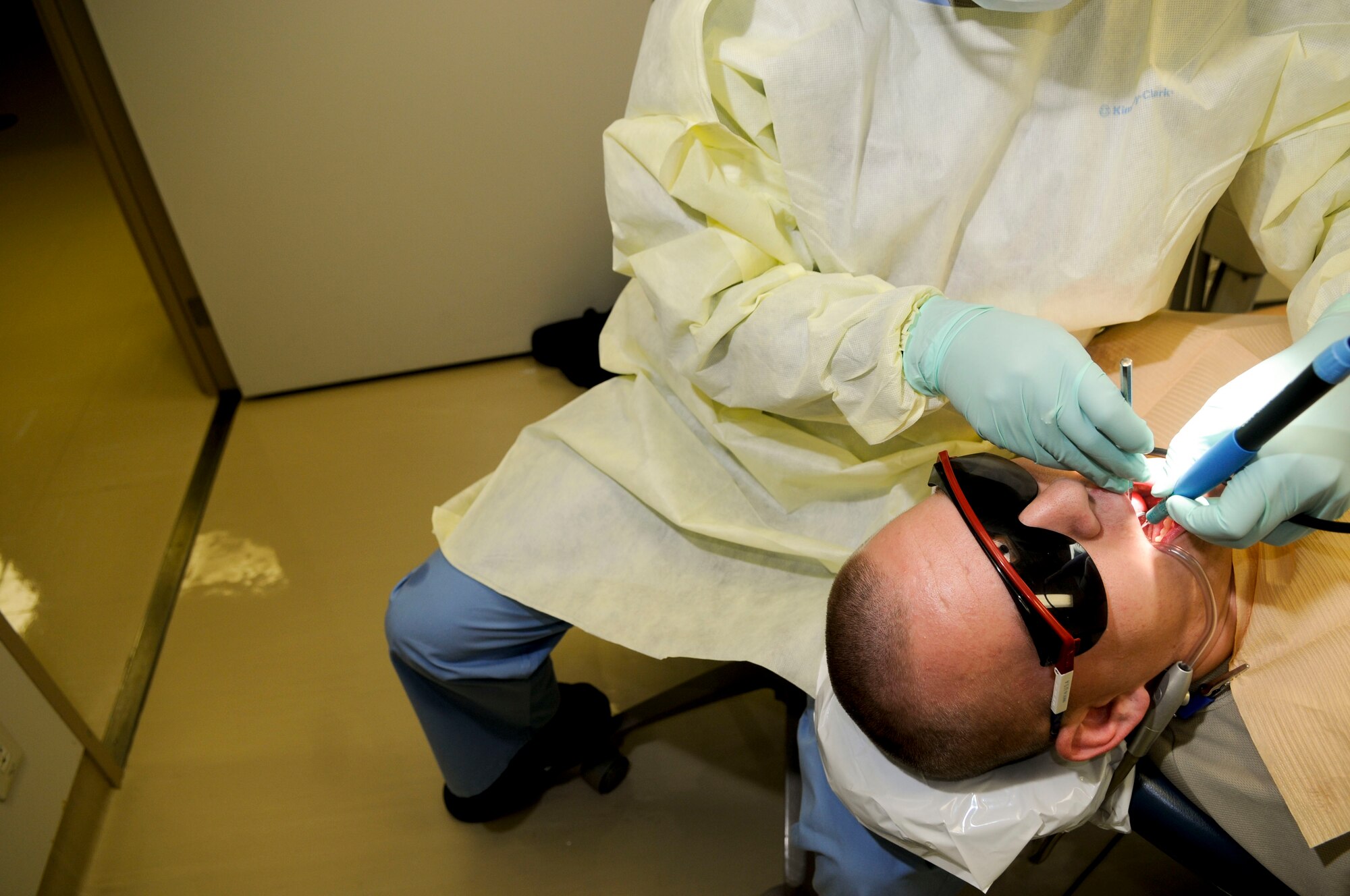 Senior Airman Allicen Demer, a dental technician with the 18th Dental Squadron, cleans the teeth of Senior Airman Elijah Bacchus, 18th Component Maintenance Squadron, March 10. The dental clinic on Kadena sees around 320 people per day and takes care of their dental needs. (U.S. Air Force photo/ Airmen 1st Class Brooke P. Beers)