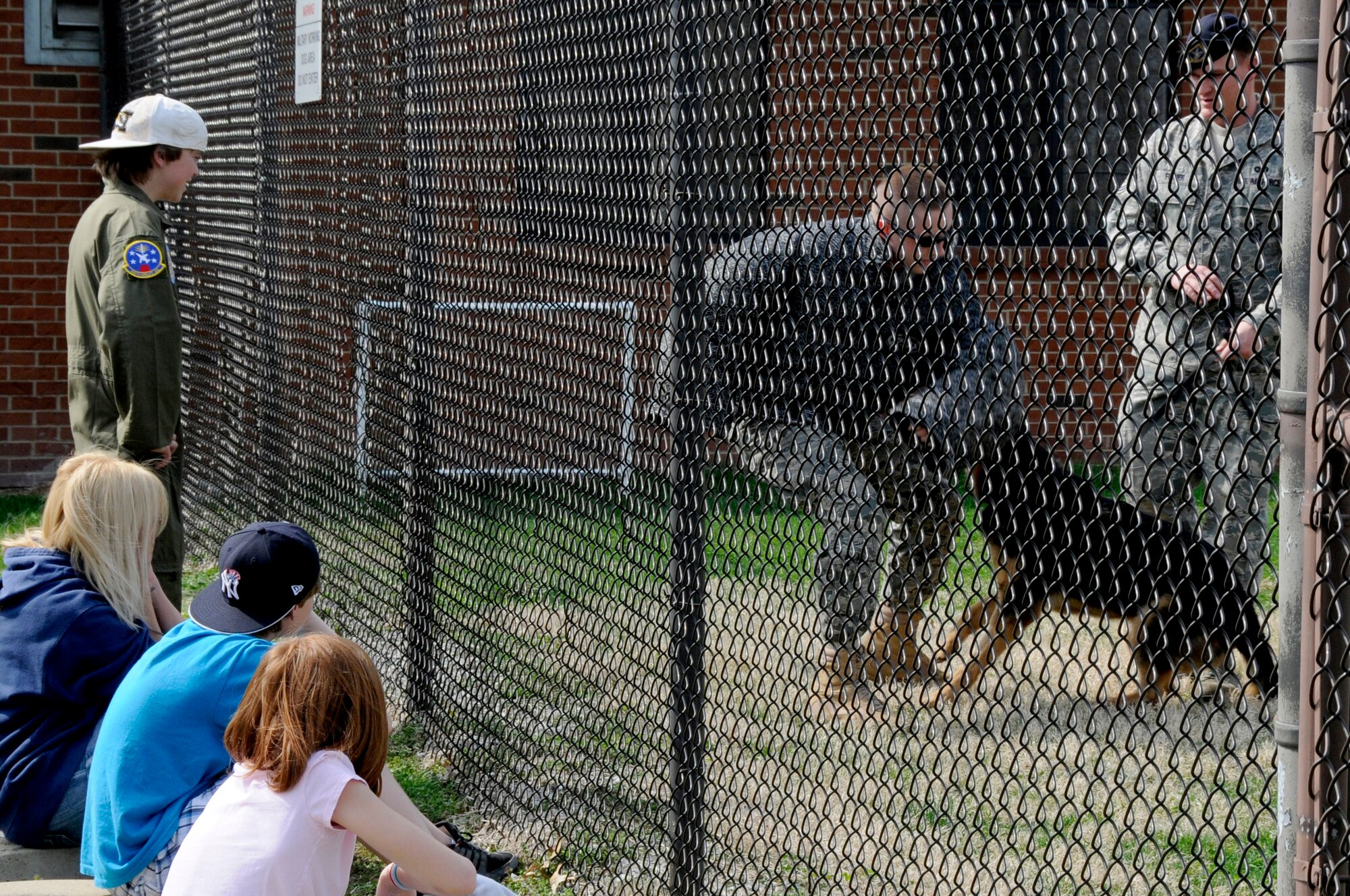 Hunter Bozaich, his mother Christine and his friends watch a military working dog demonstration during his visit for the Pilot for a Day program, March 21, 2011 at Scott Air Force Base, Ill. Hunter, who is diagnosed with Cystic Fibrosis was nominated by Cardinal Glennon Children's Medical Center to come to Scott and be a pilot for a day. His day consisted of multiple events and tours to include a C-40 Static, a military working dog demonstration, tower tour, and a ride in a flight simulator. (U.S. Air Force photo/Staff Sgt. Brian J. Valencia)
