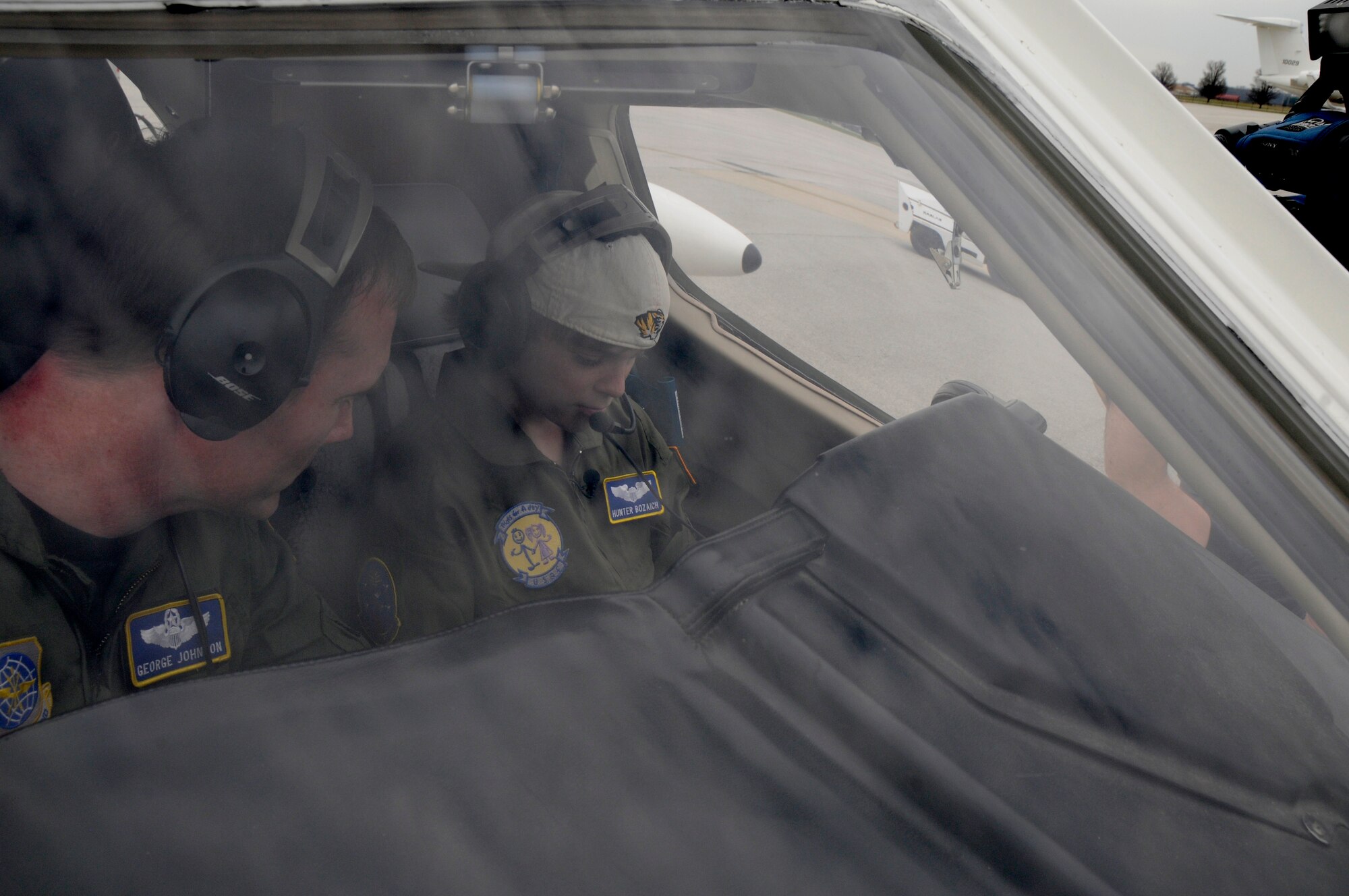 Hunter Bozaich sits in the cockpit of a C-21 with Lt. Col. George Johnson, 458th Airlift Squadron, during his visit for the Pilot for a Day program, March 21, 2011 at Scott Air Force Base, Ill. Hunter, who is diagnosed with Cystic Fibrosis was nominated by Cardinal Glennon Children's Medical Center to come to Scott and be a pilot for a day. His day consisted of multiple events and tours to include a C-40 Static, a military working dog demonstration, tower tour, a taxi ride in a C-21, and a ride in a flight simulator. (U.S. Air Force photo/Staff Sgt. Brian J. Valencia)