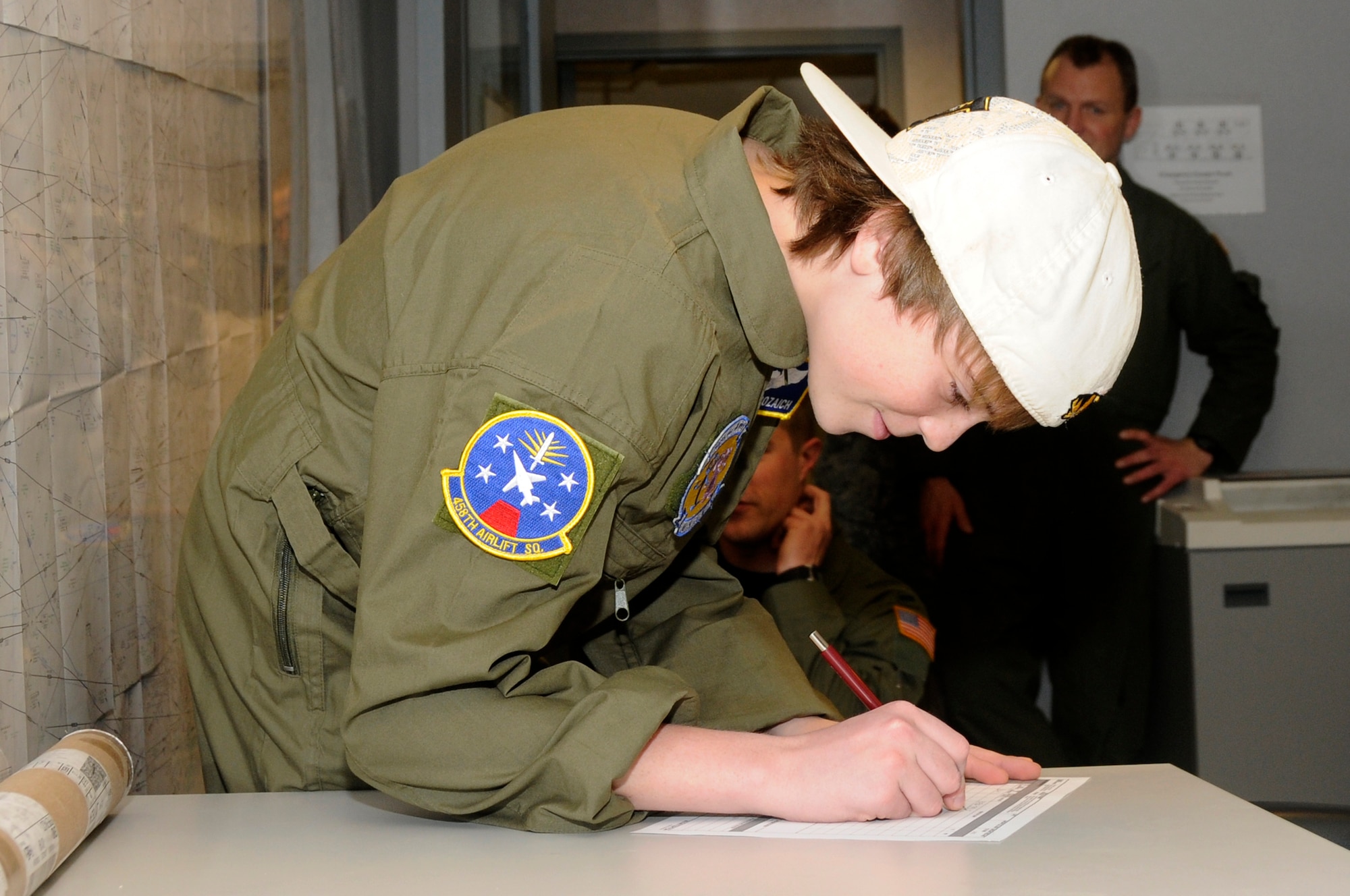 Hunter Bozaich draws up a flight plan at the 458th Airlift Squadron during his visit for the Pilot for a Day program, March 21, 2011 at Scott Air Force Base, Ill. Hunter, who is diagnosed with Cystic Fibrosis was nominated by Cardinal Glennon Children's Medical Center to come to Scott and be a pilot for a day. His day consisted of multiple events and tours to include a C-40 Static, a military working dog demonstration, tower tour, and a ride in a flight simulator. (U.S. Air Force photo/Staff Sgt. Brian J. Valencia) 