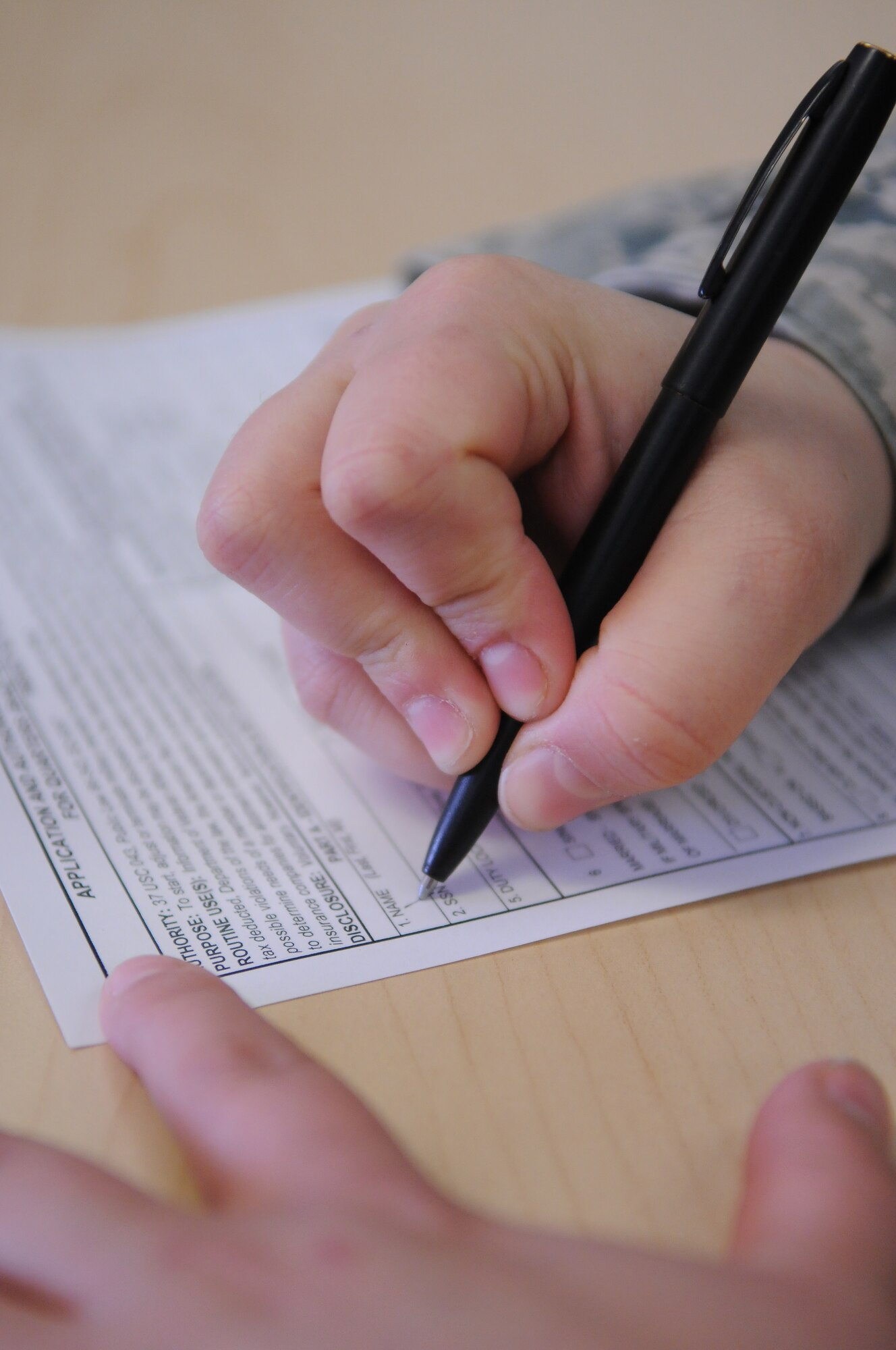 An Airman fills out a form while waiting in the finance office customer service area March 21, 2011, Eielson Air Force Base, Alaska. All forms are audited to make sure they are filled out correctly and will not be returned for errors by the Air Force Financial Services. The 354th Comptroller Squadron financial services flight is responsible for military, civilian and travel pay. (U.S. Air Force photo/Senior Airman Rachelle Coleman)