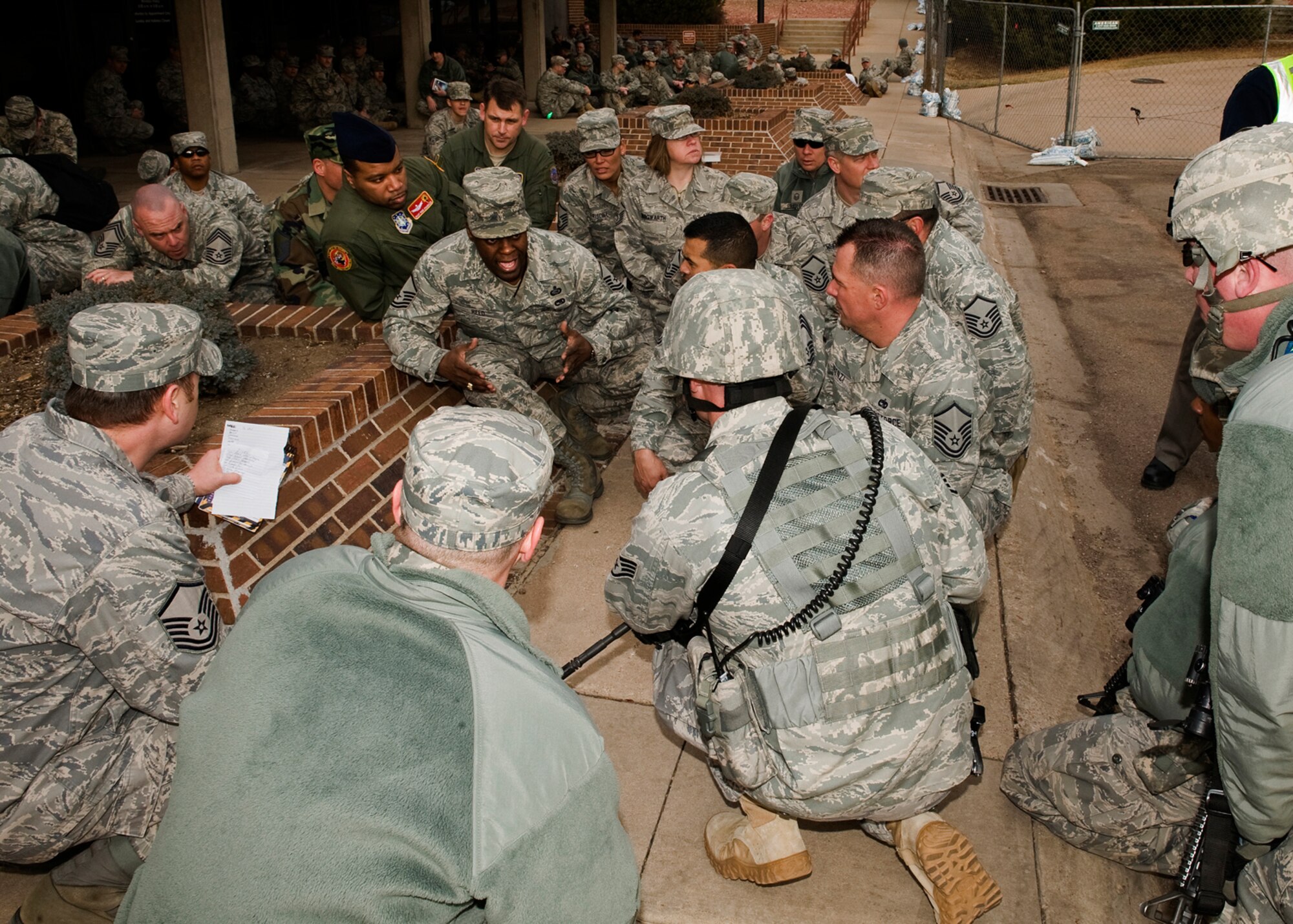 Senior NCOs and officers from the 21st Space Wing discuss security measures and procedures with 21st Security Force Squadron members after a simulated explosion in the base auditorium March 15. The explosion was part of an emergency management exercise in which the wing’s ability to respond and react during emergency scenarios was evaluated. The EME was part of the wing’s Operational Readiness Inspection and Unit Compliance Inspection, which started Feb. 28 and concluded March 21. (U.S. Air Force photo/Craig Denton)