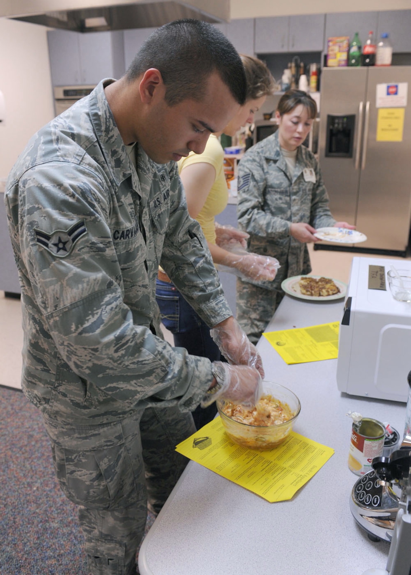 DYESS AIR FORCE BASE, Texas – Airman 1st Class Hossmann Carvajalino, 7th Medical Group, prepares food to be cooked March 18 during a microwave cooking class at the Health and Wellness Center here. The class is designed to teach dorm residents the flexibility of microwave cooking so they're not bound to the dining facility. Airmen learned to cook cinnamon rolls, chicken dip and sweet and sour chicken. March is National Nutrition Month and Dyess Health and Wellness Center is offering nutrition bingo March 24 from 5-6 p.m., kids healthy snack class March 25 from 10-11 a.m. and a snack bar challenge that ends March 25. For more information, visit the HAWC at the fitness center or call (325) 696-4140. (U.S Air Force Photo/ Senior Airman Chelsea Cummings)