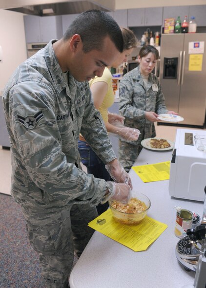 DYESS AIR FORCE BASE, Texas – Airman 1st Class Hossmann Carvajalino, 7th Medical Group, prepares food to be cooked March 18 during a microwave cooking class at the Health and Wellness Center here. The class is designed to teach dorm residents the flexibility of microwave cooking so they're not bound to the dining facility. Airmen learned to cook cinnamon rolls, chicken dip and sweet and sour chicken. March is National Nutrition Month and Dyess Health and Wellness Center is offering nutrition bingo March 24 from 5-6 p.m., kids healthy snack class March 25 from 10-11 a.m. and a snack bar challenge that ends March 25. For more information, visit the HAWC at the fitness center or call (325) 696-4140. (U.S Air Force Photo/ Senior Airman Chelsea Cummings)