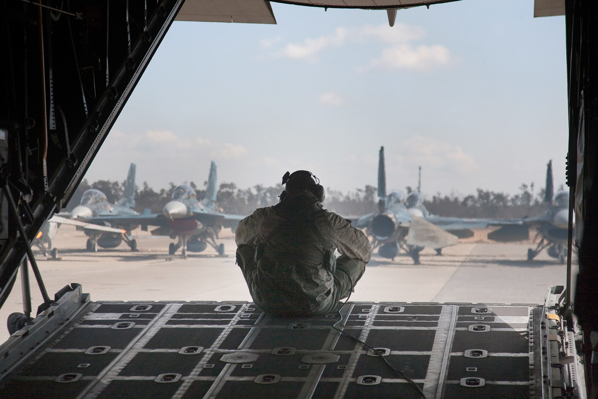 Senior Airman Ramon Mortensen looks at damaged F-2 aircraft after landing March 18, 2011, at Matsushima Airfield to drop off relief supplies. The aircraft were damaged after an earthquake and subsequent tsunami rocked Northeastern Japan. Airman Mortensen is a loadmaster assigned to the 17th Special Operations Squadron. (U.S. Air Force photo/Osakabe Yasuo) 