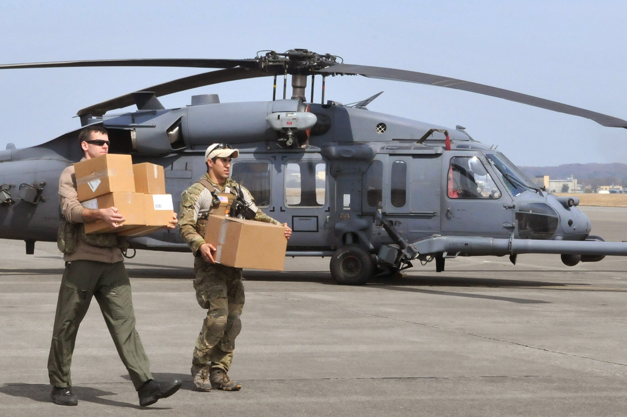 Two Airmen carry medical supplies to an HH-60G Pave Hawk prior to take off March 20, 2011, at Yokota Air Base, Japan. Airmen from the 33rd Rescue Squadron successfully transported supplies to displaced peoples in Kessenuma City, in support of Operation Tomodachi. Kessenuma experienced massive destruction from the earthquake and tsunami in northeastern Japan, March 11. (U.S. Air Force photo/2nd Lt. Christopher Love) 
