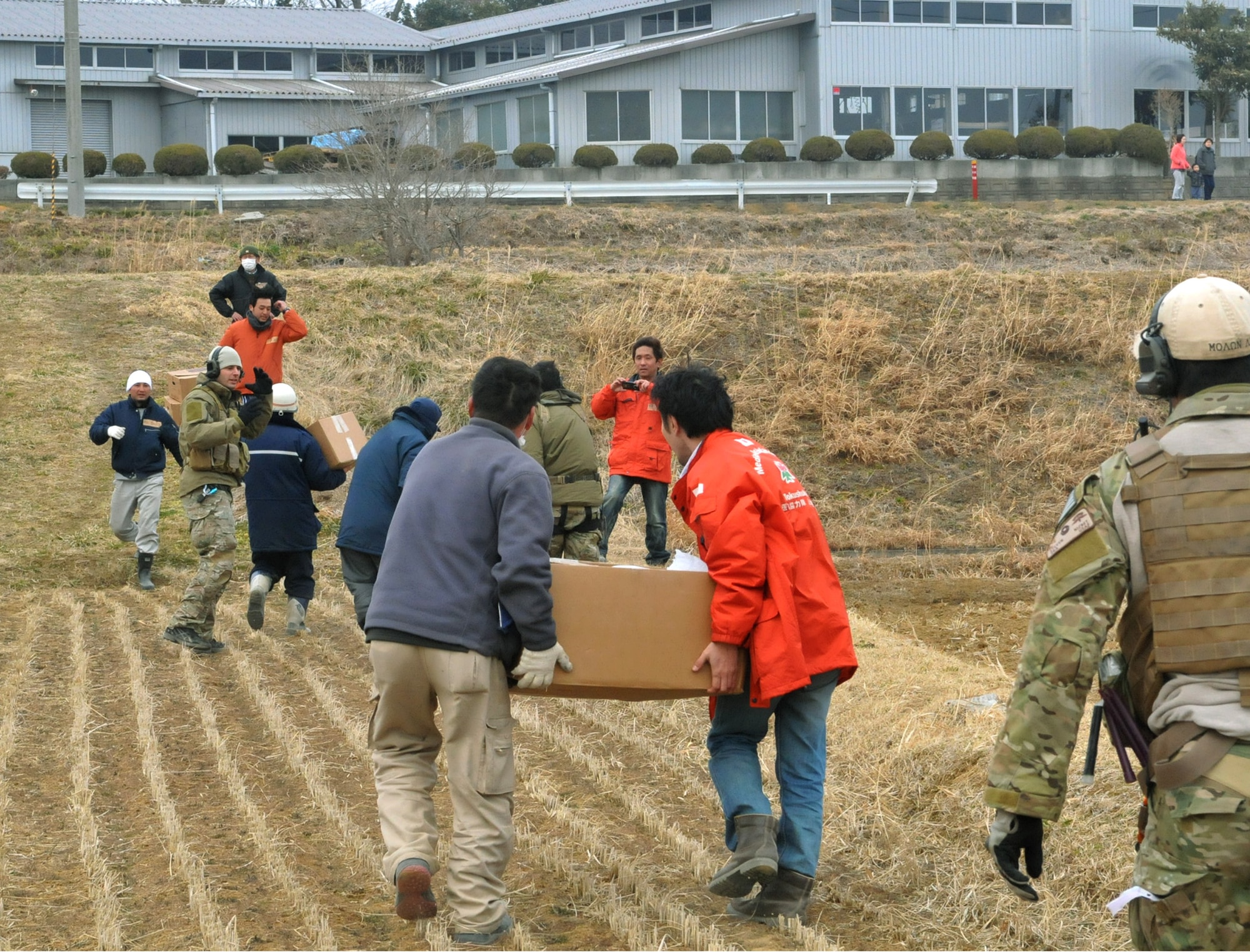 Airmen work alongside a team of Japanese medical workers to unload food, water and medical supplies from a pair of HH-60G Pave Hawks March 20, 2011, at Yokota Air Base, Japan. Airmen from the 33rd Rescue Squadron successfully transported supplies to displaced people in Kessenuma City, in support of Operation Tomodachi. Kessenuma experienced massive destruction from the earthquake and tsunami in northeastern Japan, March 11. (U.S. Air Force photo/2nd Lt. Christopher Love) 
