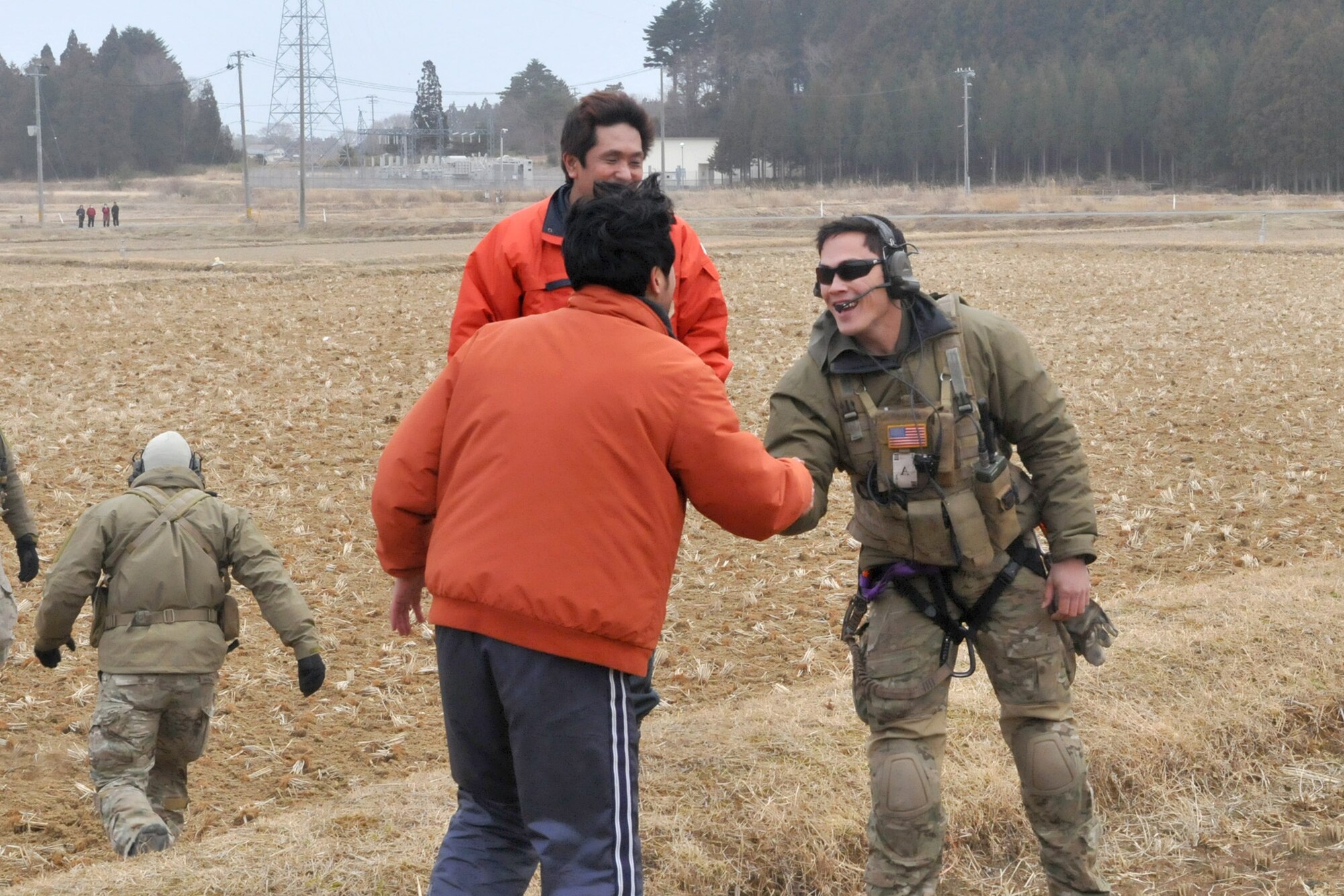 A Japanese relief worker shows his appreciation after a pair of HH-60G Pave Hawks deliver food, water and medical supplies March 20, 2011, at Yokota Air Base, Japan. Airmen from the 33rd Rescue Squadron successfully transported supplies to displaced people in Kessenuma City, in support of Operation Tomodachi. Kessenuma experienced massive destruction from the earthquake and tsunami in northeastern Japan, March 11. (U.S. Air Force photo/2nd Lt. Christopher Love) 
