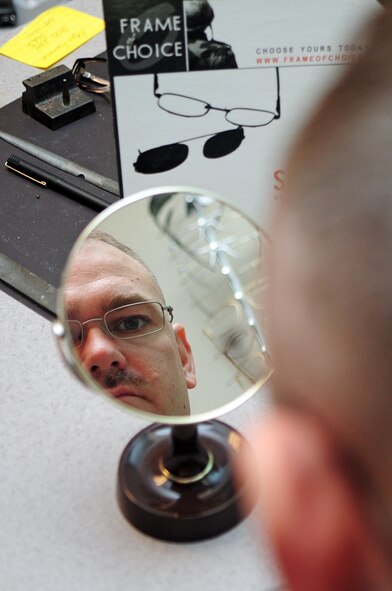 Tech. Sgt. Timothy Huff, 2nd Communications Squadron, checks his reflection while trying on a new set of glasses at the optometry office located in the 2nd Medical Group Clinic at Barksdale Air Force Base, La., March 21. Active duty Airmen who require corrective lenses are allotted one pair of frames per year, which they may choose from a variety of in-regulation frames the clinic has to offer. (U.S. Air Force photo/Senior Airman Joanna M. Kresge)