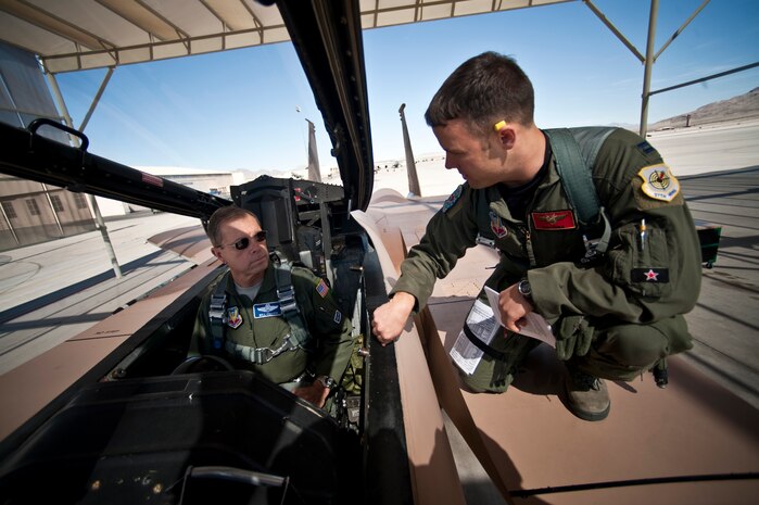 NELLIS AIR FORCE BASE, Nev. -- Gen. William M. Fraser III, commander of Air Combat Command, and Capt. Joshua Fogle, 65th Aggressor Squadron pilot, discuss egress procedures before a training mission in a F-15 Eagle during Red Flag 11-3, March 9. During his weeklong visit here, General Fraser also flew on an E-3 Sentry Airborne Warning and Control System aircraft. (U.S. Air Force photo/Tech. Sgt. Michael R. Holzworth)