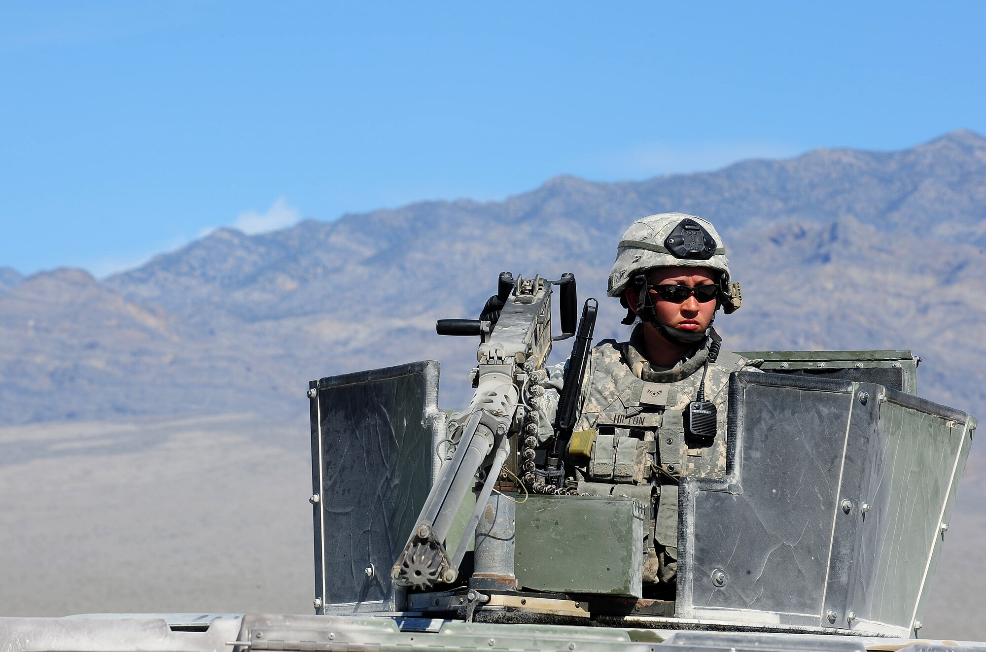 NEVADA TEST AND TRAINING RANGE, Nev.-- Airman 1st Class Meghan Hilton, 822nd Base Defense Squadron member, watches out for danger during a DESERT EAGLE patrol as she mans the .50-caliber machine gun. She has been shooting since she was 7. At About the same time, she decided she wanted to join the military.  (U.S. Air Force photo/Senior Airman Stephanie Mancha) (RELEASED)
