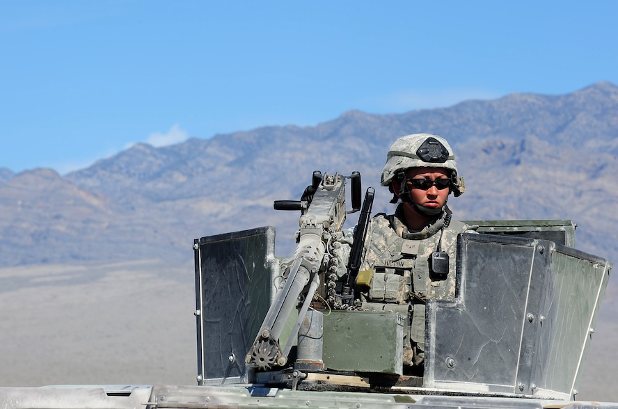 NEVADA TEST AND TRAINING RANGE, Nev.-- Airman 1st Class Meghan Hilton, 822nd Base Defense Squadron member, watches out for danger during a DESERT EAGLE patrol as she mans the .50-caliber machine gun. She has been shooting since she was 7. At About the same time, she decided she wanted to join the military.  (U.S. Air Force photo/Senior Airman Stephanie Mancha) (RELEASED)