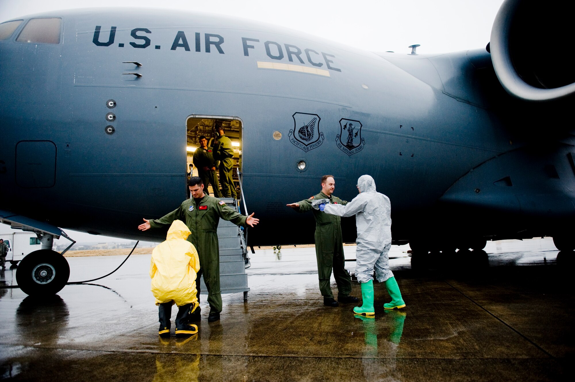 YOKOTA AIR BASE, Japan -- Senior Airman Daniel Burdick, 18th Aerospace Medicine Squadron, and Senior Airman Eva Gaus, 374th Civil Engineer Squadron, scan for possible presence of radiation exposure on a C-17 Globemaster III here March 21. The Airmen screened the aircraft and aircrew members upon return from a flight to northern Japan. (U.S. Air Force photo/Staff Sgt. Jonathan Steffen)