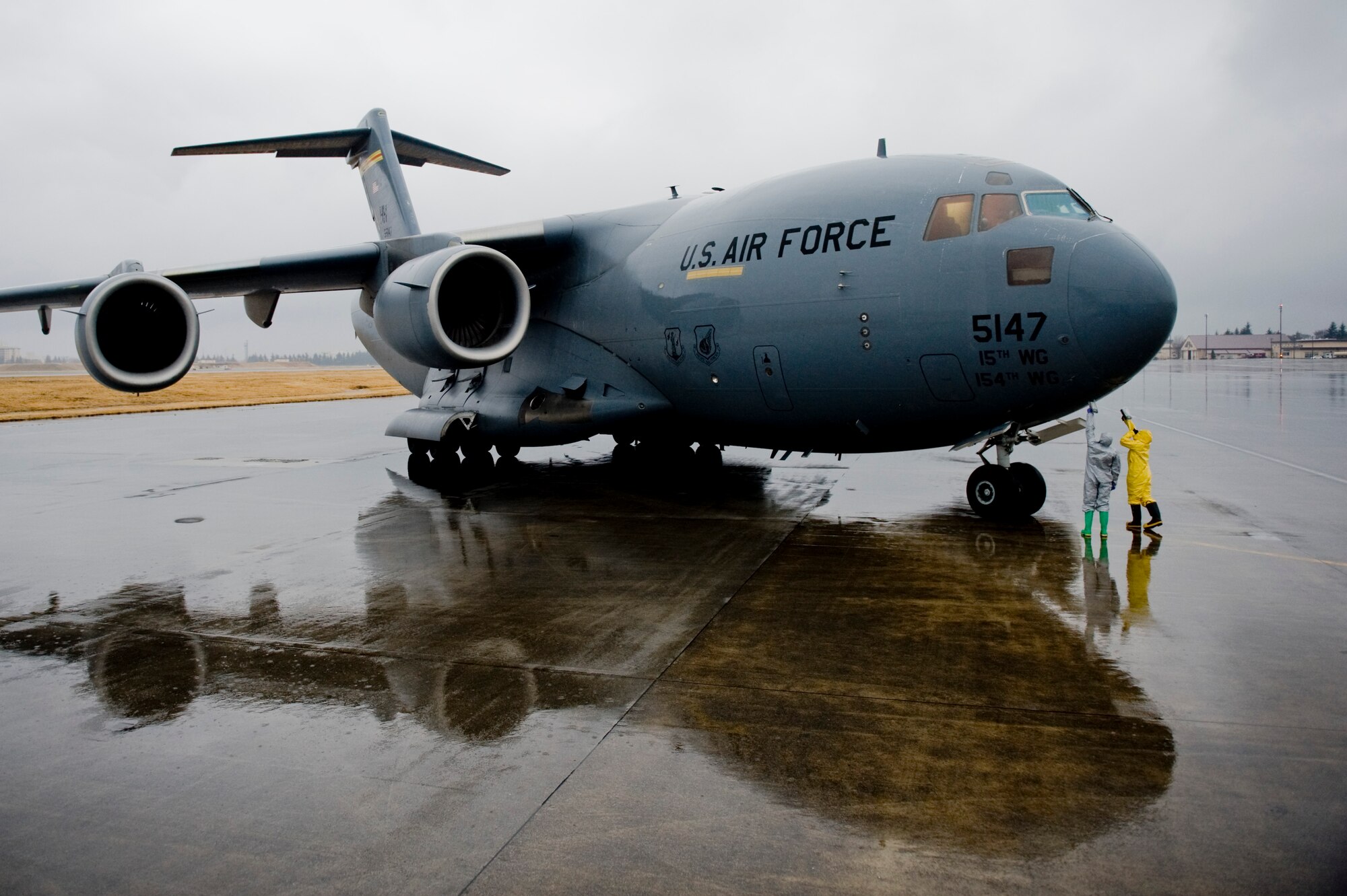 YOKOTA AIR BASE, Japan -- Senior Airman Daniel Burdick, 18th Aerospace Medicine Squadron, and Senior Airman Eva Gaus, 374th Civil Engineer Squadron, scan for possible presence of radiation exposure on a C-17 Globemaster III here March 21. The Airmen screened the aircraft and aircrew members upon return from a flight to northern Japan. (U.S. Air Force photo/Staff Sgt. Jonathan Steffen)