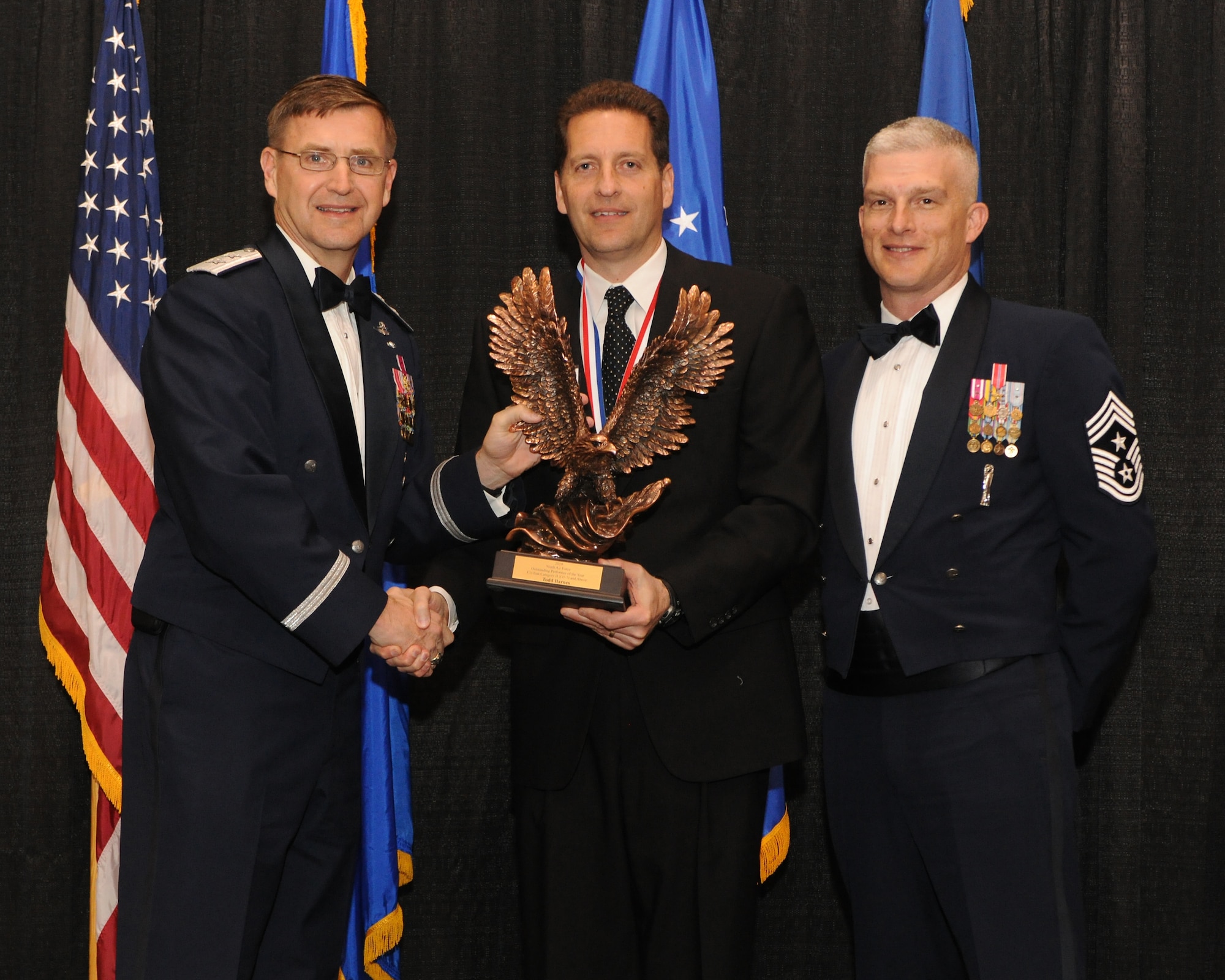 Maj. Gen. Stephen Hoog, Ninth Air Force commander, and Chief Master Sgt. Robert Brooks, 9 AF command chief, present Mr. Todd Barnes, 633d Civil Engineer Squadron Operations Flight deputy chief, with the Civilian of the Year Category 2 award during the 2010 9 AF Outstanding Performer of the Year Awards Banquet at the James H. Rainwater Conference Center in Valdosta, Ga., March 10, 2011. Mr. Barnes oversees 280 Airmen and civilians tasked with infrastructure maintenance at Langley Air Force Base, Va., including facilities, runways, roads, electrical systems and plumbing across the installation. (U.S. Air Force photo by Airman 1st Class Benjamin Wiseman/RELEASED)