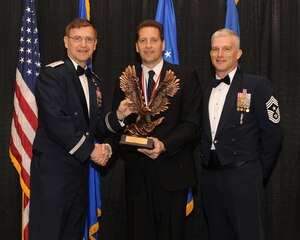 Maj. Gen. Stephen Hoog, Ninth Air Force commander, and Chief Master Sgt. Robert Brooks, 9 AF command chief, present Mr. Todd Barnes, 633d Civil Engineer Squadron Operations Flight deputy chief, with the Civilian of the Year Category 2 award during the 2010 9 AF Outstanding Performer of the Year Awards Banquet at the James H. Rainwater Conference Center in Valdosta, Ga., March 10, 2011. Mr. Barnes oversees 280 Airmen and civilians tasked with infrastructure maintenance at Langley Air Force Base, Va., including facilities, runways, roads, electrical systems and plumbing across the installation. (U.S. Air Force photo by Airman 1st Class Benjamin Wiseman/RELEASED)