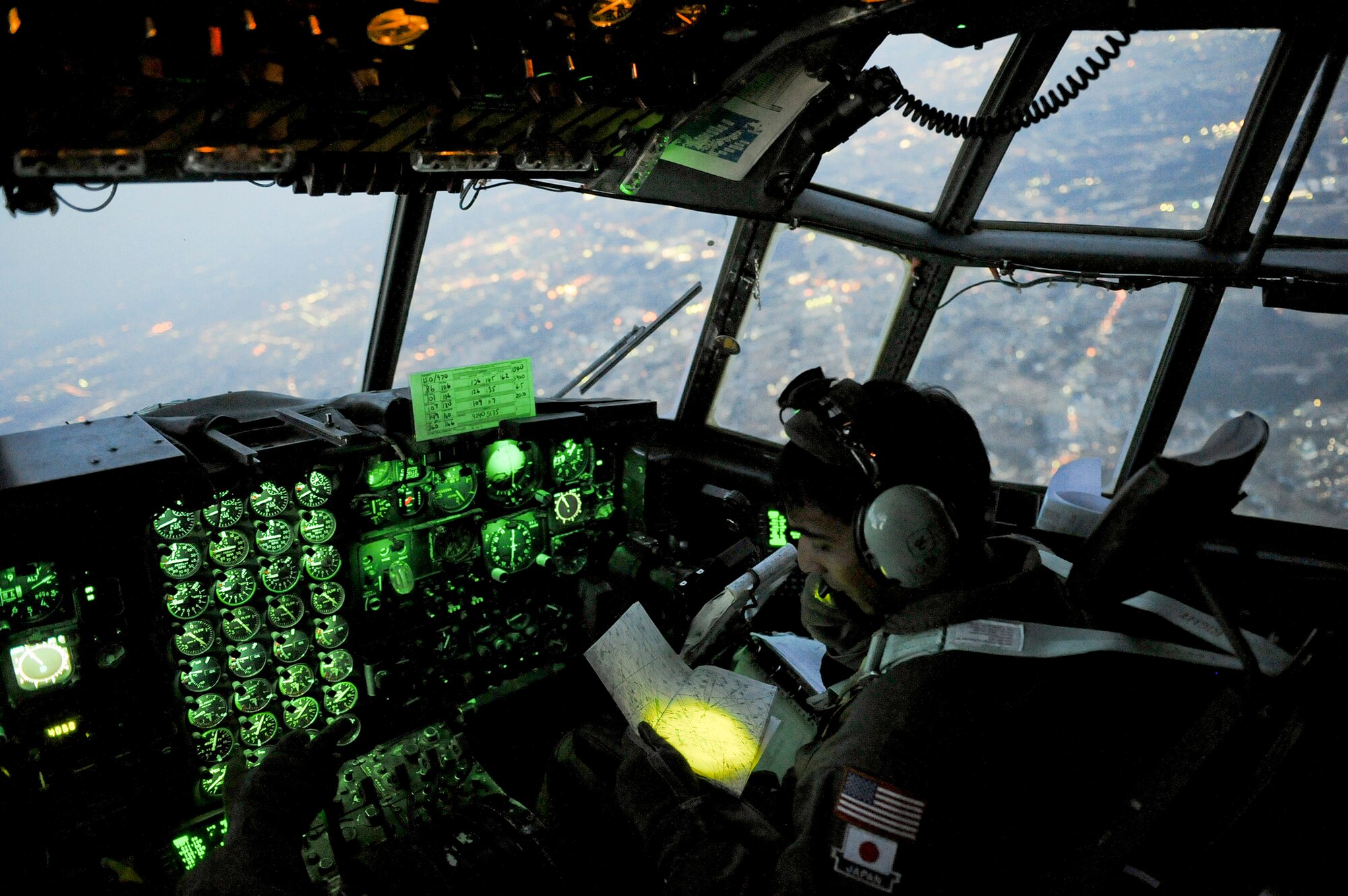 Capt. Yuri Batten looks at a map while flying a C-130 Hercules filled with medical supplies March 19, 2011, over Yokota, Japan. Captain Batten is assigned to the 36th Airlift Squadron.  (U.S. Air Force photo/Staff Sgt. Jonathan Steffen)