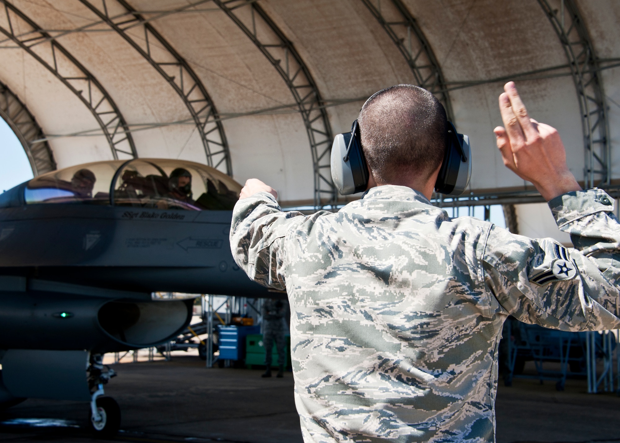 Airman 1st Class Andrew Merriman, 56th Aircraft Maintenance Squadron, marshals out an F-16 Fighting Falcon for a sortie at Eglin Air Force Base, Fla., March 18.  The F-16s were brought here to provide familiarization training to the 33rd Fighter Wing pilots prior to the arrival of the F-35 and to establish a “battle rhythm” for the 33rd flightline operations.  Currently, Marines and Air Force pilots are completing daily sorties.  (U.S. Air Force photo/Samuel King Jr.)