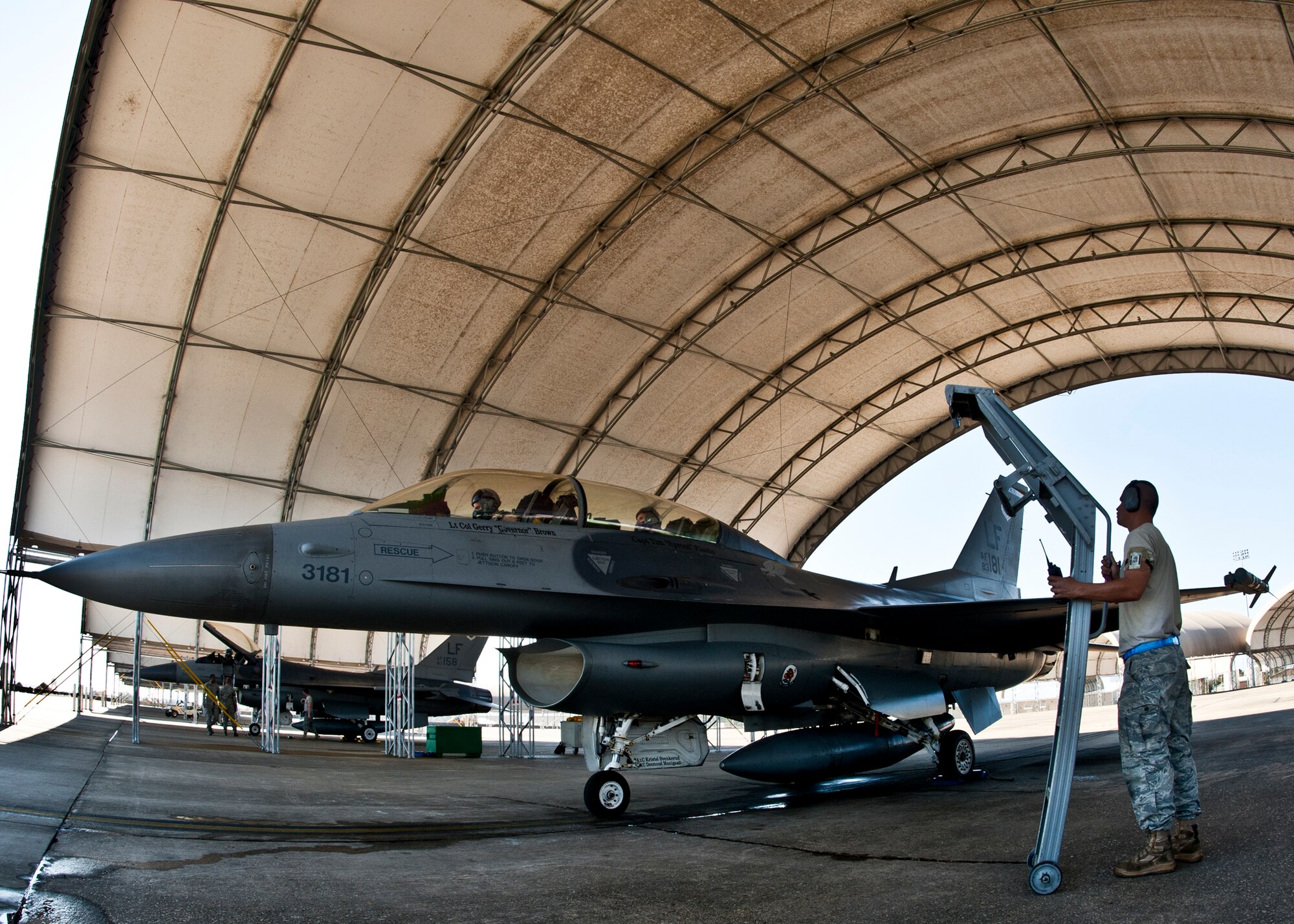 A maintainer with the 56th Aircraft Maintenance Squadron from Luke Air Force Base, Ariz., waits to bring the ladder to the recently returned F-16 at Eglin Air Force Base, Fla., March 18. The F-16s were brought here to provide familiarization training to the 33rd Fighter Wing pilots prior to the arrival of the F-35 and to establish a “battle rhythm” for the 33rd flightline operations.  Currently, Marines and Air Force pilots are completing daily sorties.  (U.S. Air Force photo/Samuel King Jr.)