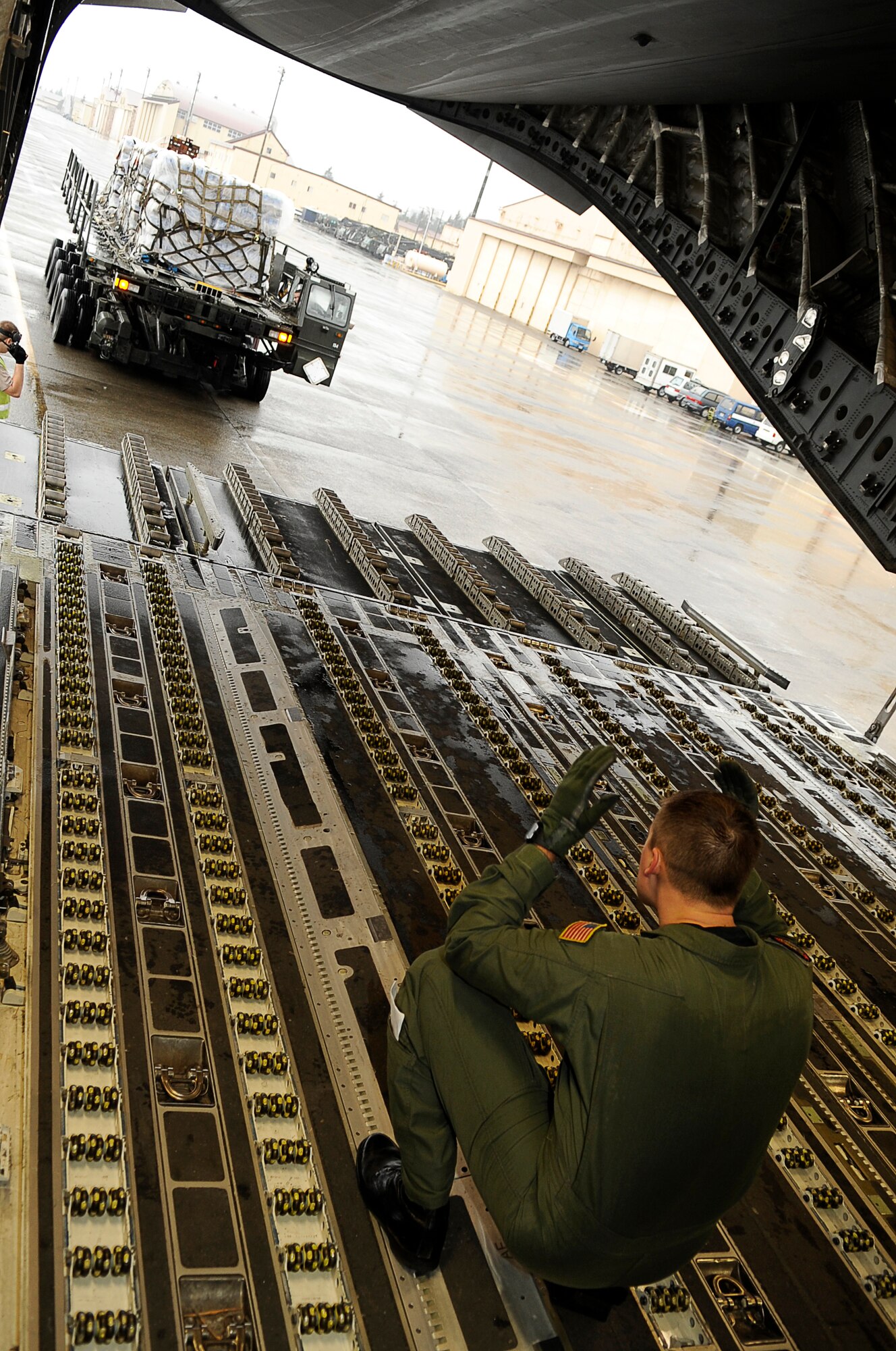 YOKOTA AIR BASE, Japan -- As part of Operation Tomodachi, Staff Sgt. Chris Baker guides a K-loader with humanitarian supplies behind a C-17 Globemaster III March 21, 2011. Crews unloaded the water and other relief items at Sendai Airport as American forces work closely with their Japanese counterparts to aid the people of Japan in the aftermath of an 8.9 earthquake, which hit Japan March 11. ?Tomodachi? is a Japanese word meaning ?friends.? Sergeant Baker is a member of the 535th Airlift Squadron, Joint Base Pearl Harbor-Hickam, Hawaii. (U.S. Air Force photo by/Master Sgt. Jeromy K. Cross/released) 