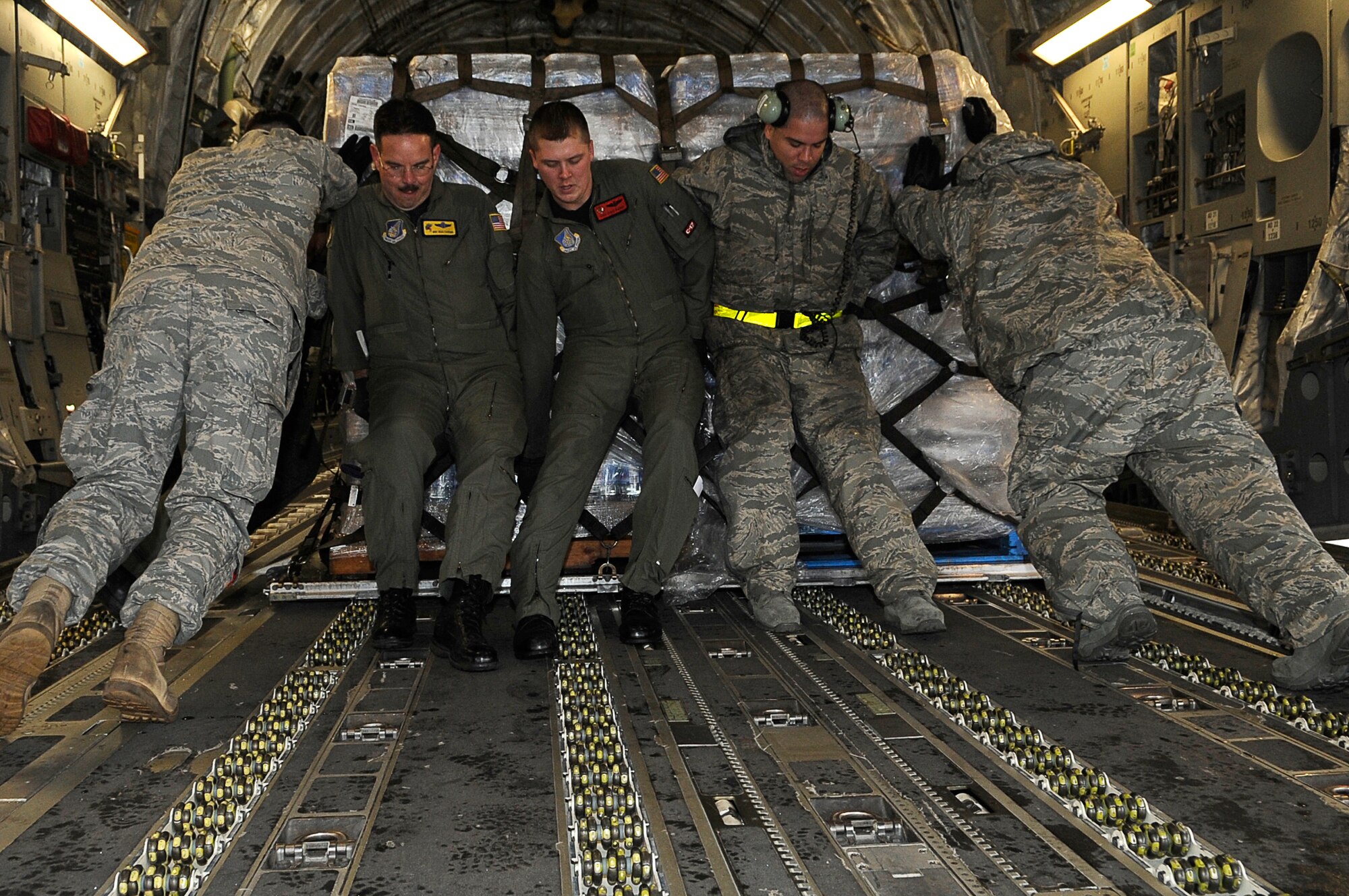 YOKOTA AIR BASE, Japan -- Airmen load a pallet of water onto a C-17 Globemaster III March 21, 2011. Crews unloaded the water and other relief items at Sendai Airport as American forces work closely with their Japanese counterparts to aid the people of Japan in the aftermath of an 8.9 earthquake, which hit Japan March 11. ?Tomodachi? is a Japanese word meaning ?friends.? (U.S. Air Force photo by/Master Sgt. Jeromy K. Cross/released) 