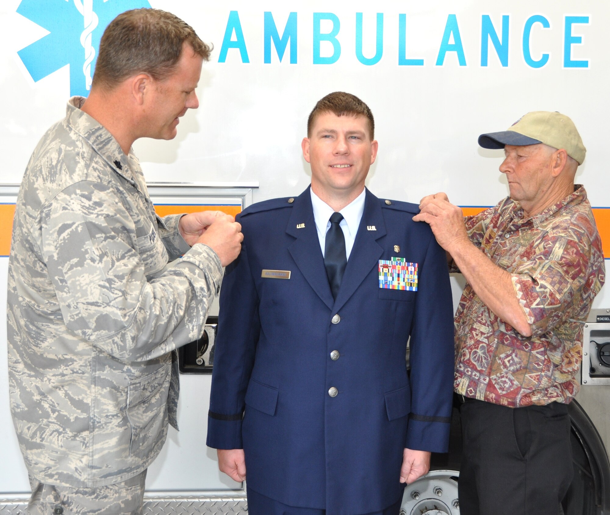 Lt. Col. (Dr.) Joseph Pocreva, left, and Dean Kalinauskas pin new rank on 	Capt. Zackery Kalinauskas’ epaulets March 2 during a promotion ceremony outside the Emergency Department.   Dr. Pocreva is commander of the 81st Medical Operations Squadron’s Emergency Services Flight.  Captain Kalinauskas is a Biloxi native born in the former Howard Memorial Hospital on Bayview Avenue, which is visible just north of the 81st Medical Group Hospital.  His grandfather, who served in the Navy, had moved to Biloxi in the 1940s from Waterbury, Conn., where his family had emigrated to from Lithuania.  His grandparents are buried in the “Old French Cemetery” just outside Keesler.  His mother is deceased and his father Dean lives in Pass Christian where he had moved from Biloxi’s “Point” after losing everything during Hurricane Katrina.   Captain Kalinauskas served 11 years as an enlisted member of the Army, subsequently enlisting in the Air Force Reserve before earning a nursing degree and being commissioned as an Air Force officer in February 2007.  He has been a “Dragon Medic” since April 2007 and leaves Keesler in July for a new assignment at Royal Air Force Lakenheath, United Kingdom. (Photo by Steve Pivnick).