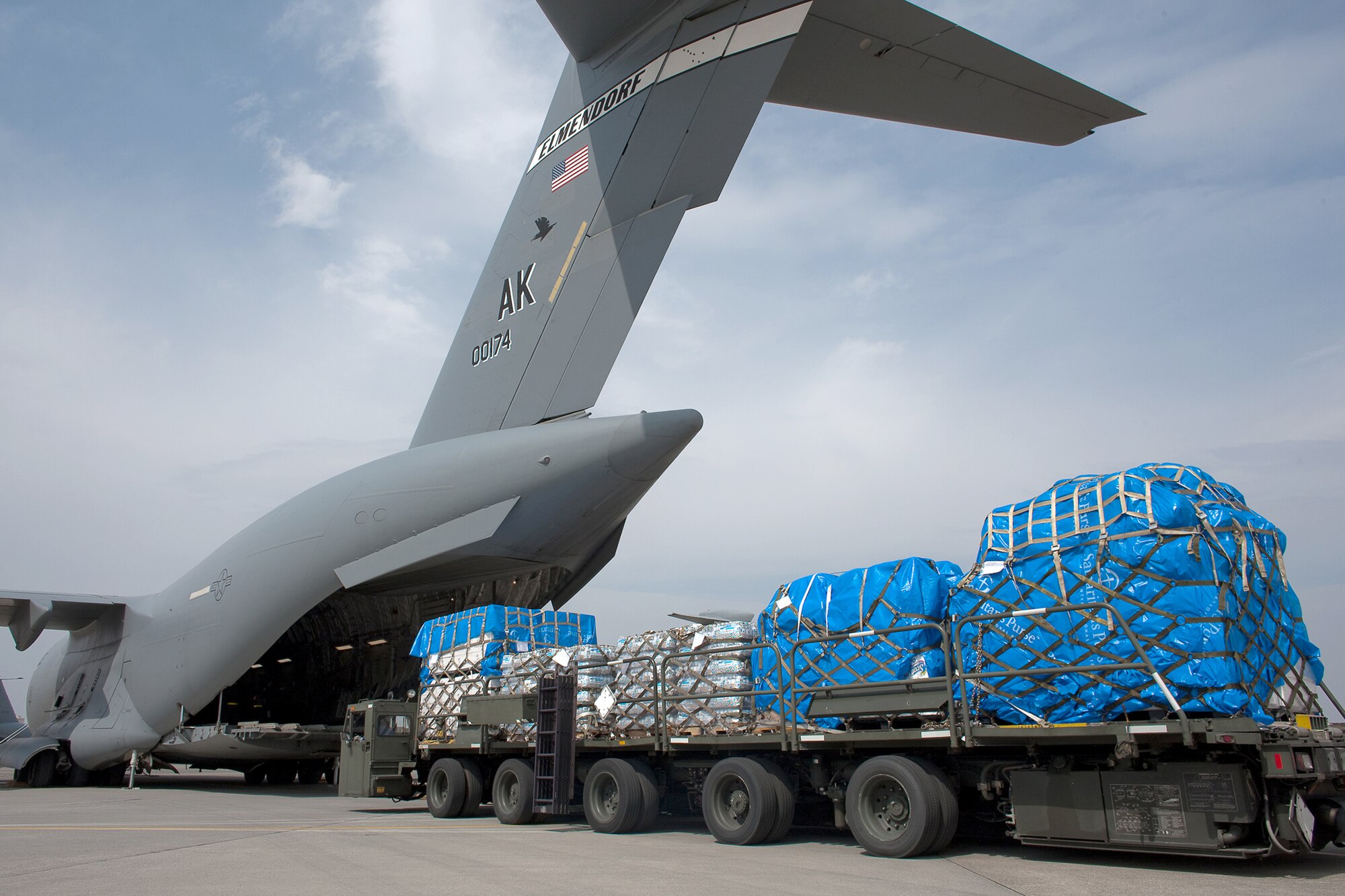 Members of the 730th Air Mobility Squadron load ten pallets of water, food and blankets onto a C-17 Globemaster III aircraft March 20, 2011, at Yokota Air Base, Japan. These were the first humanitarian relief supplies to be delivered to Sendai. (U.S. Air Force photo/Osakabe Yasuo) 